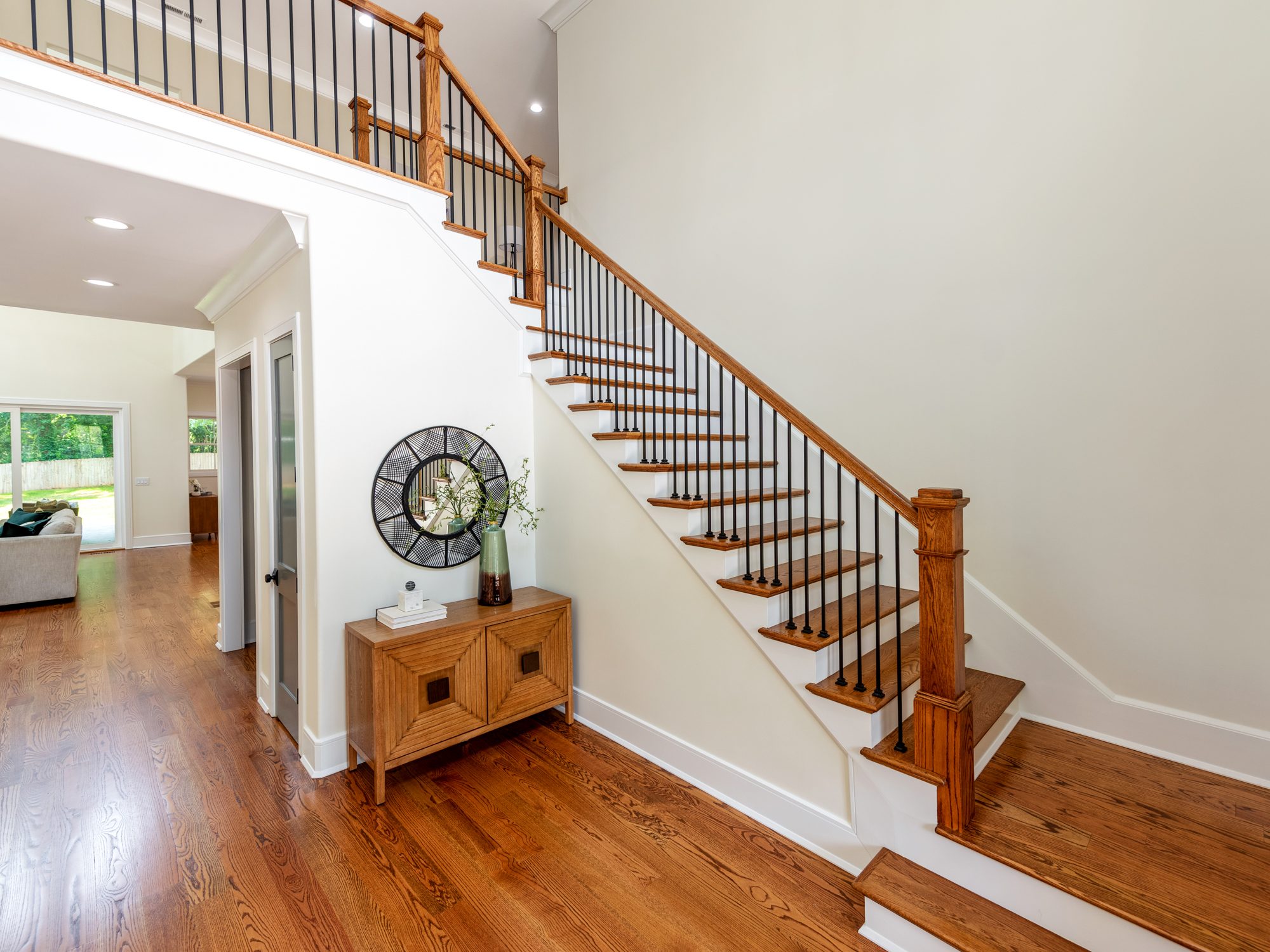Staircase with white oak treads, iron spindles, and console accent — Brantham by Stillman Properties Charlotte NC