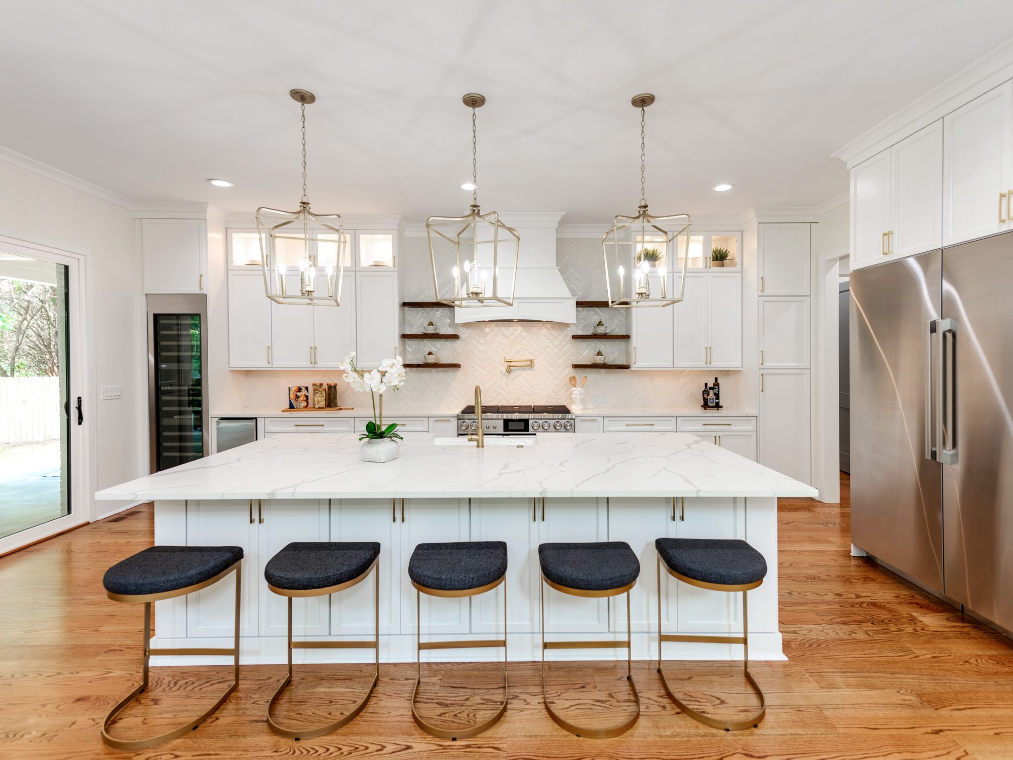 Chef's kitchen with oversized island, brass pendants, and bar seating — Brantham by Stillman Properties Charlotte NC