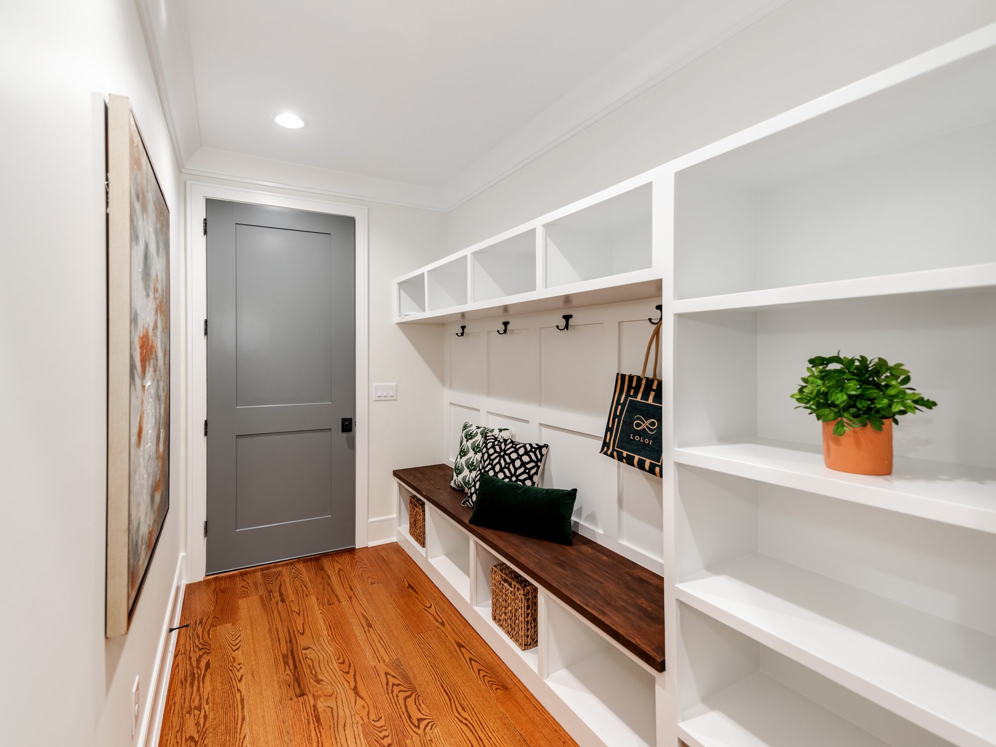 Mudroom with built-in bench, hooks, and open shelving — Brantham by Stillman Properties Charlotte NC