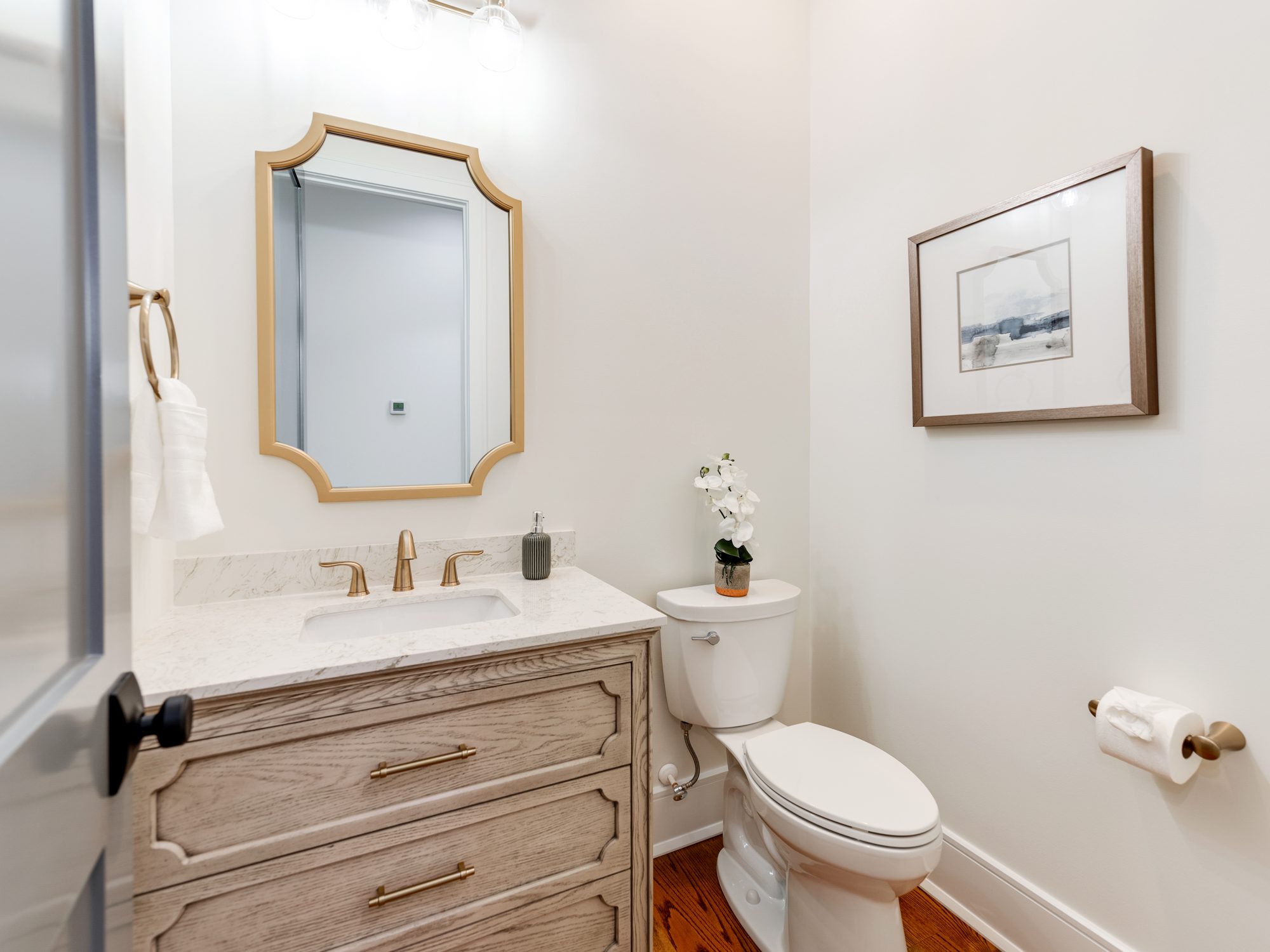 Designer powder bath with patterned wallpaper and brass fixtures — Brantham by Stillman Properties Charlotte NC
