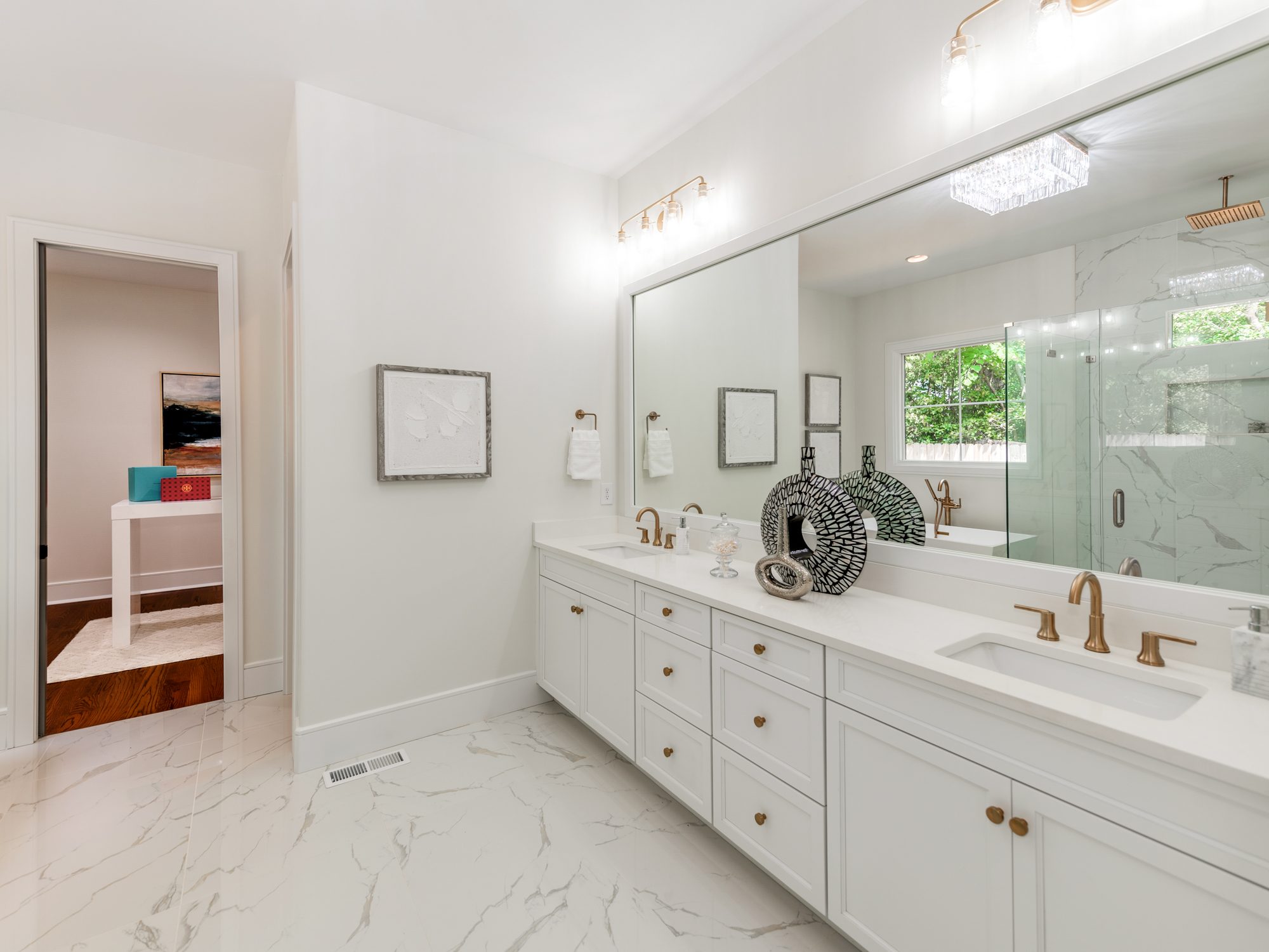 Primary bath with double vanity, brass fixtures, and marble-look tile — Brantham by Stillman Properties Charlotte NC