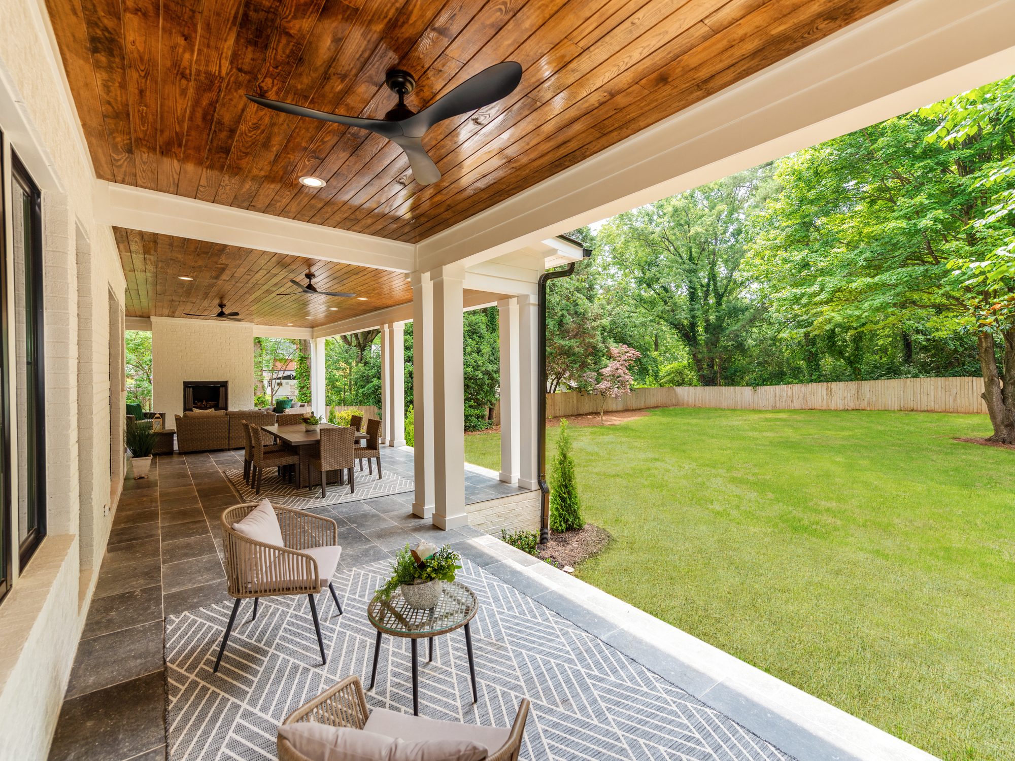 Covered rear porch with cedar ceiling, ceiling fans, and views to the backyard — Brantham by Stillman Properties Charlotte NC