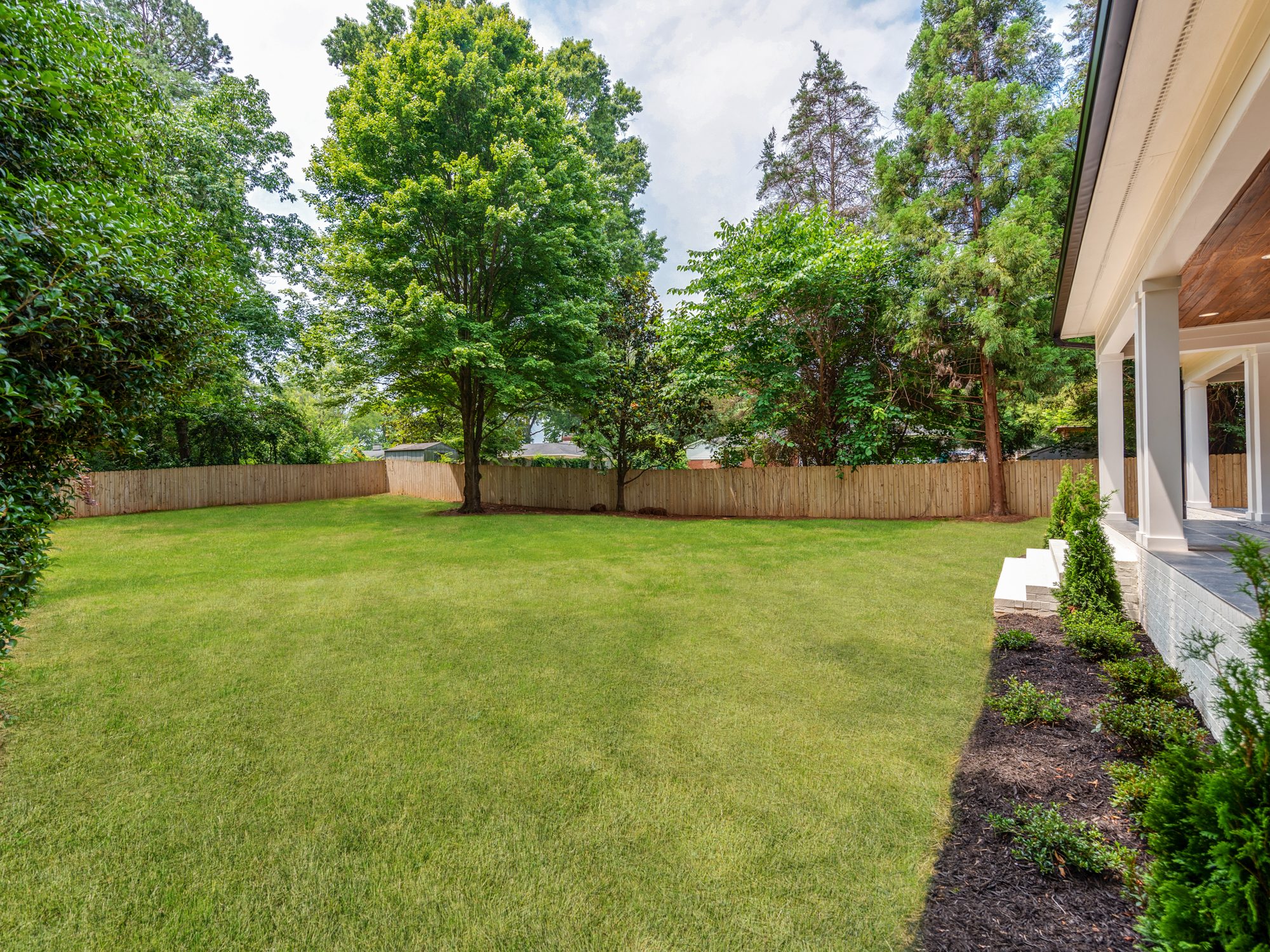 Alternate view of the fully fenced backyard from the covered porch — Brantham by Stillman Properties Charlotte NC