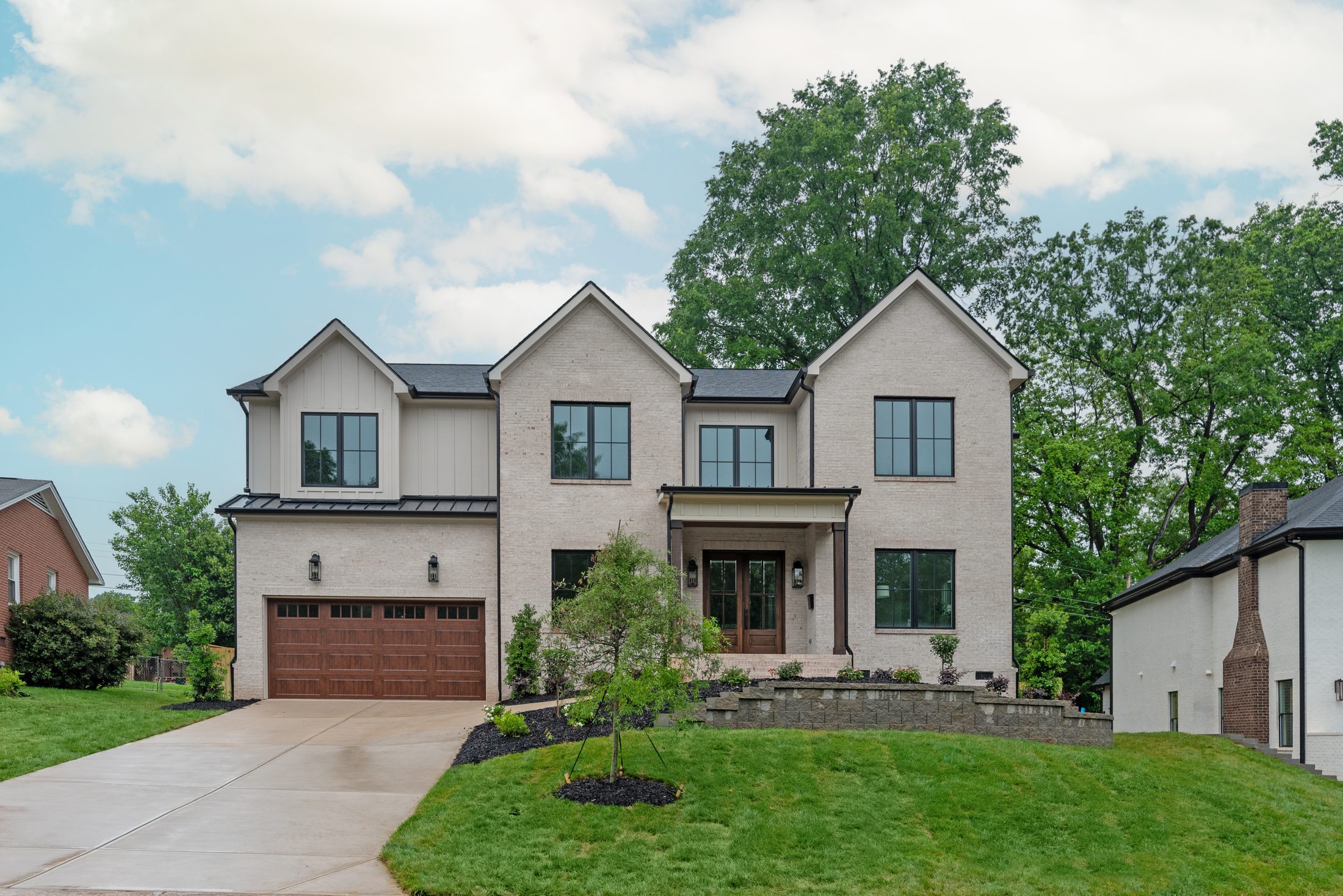 Three-quarter front view of Bywood showing the gabled roofline, painted brick, and board-and-batten siding — Stillman Properties Charlotte NC