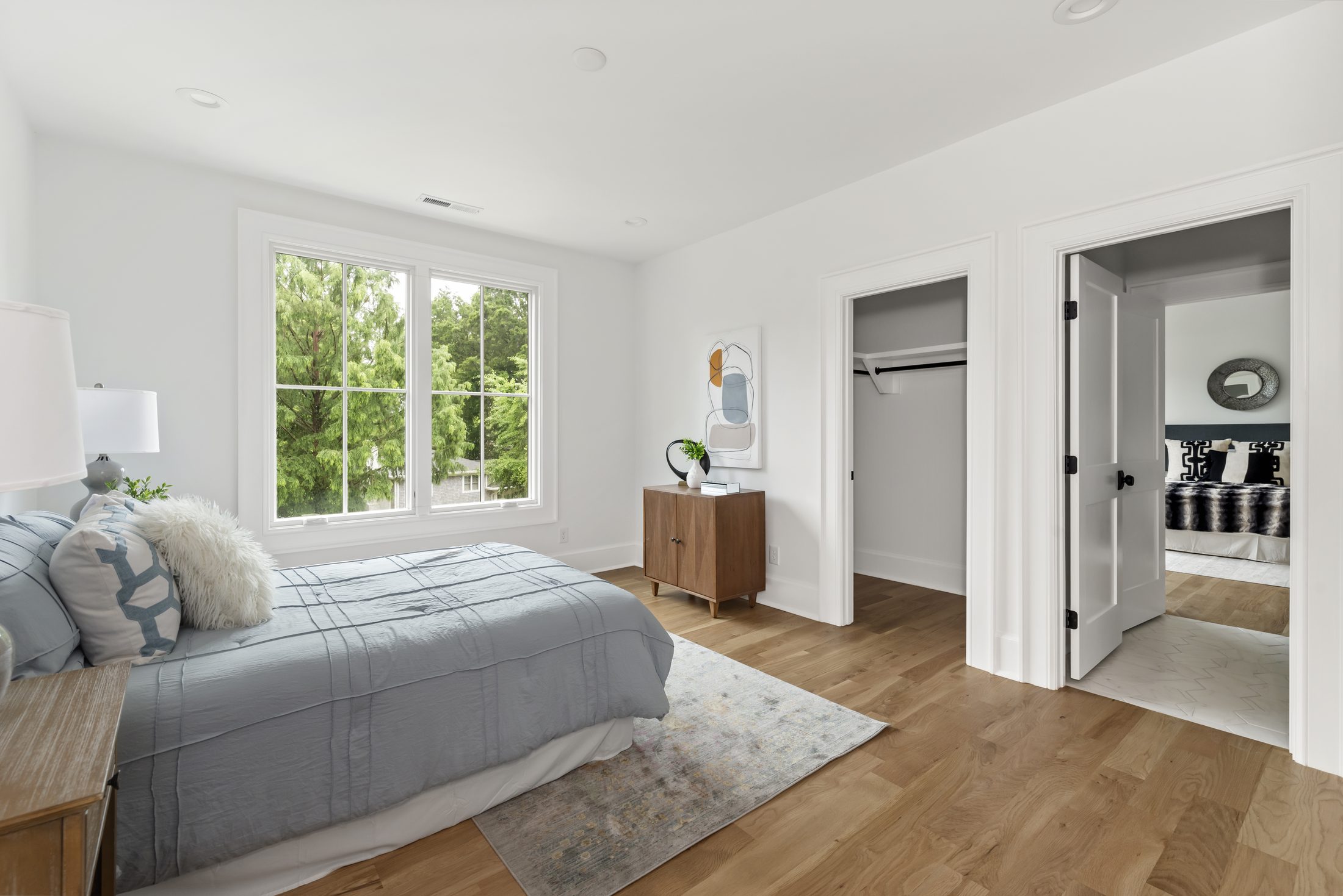 Secondary bedroom with gray bedding, a built-in closet, and an adjoining bath — Bywood by Stillman Properties Charlotte NC