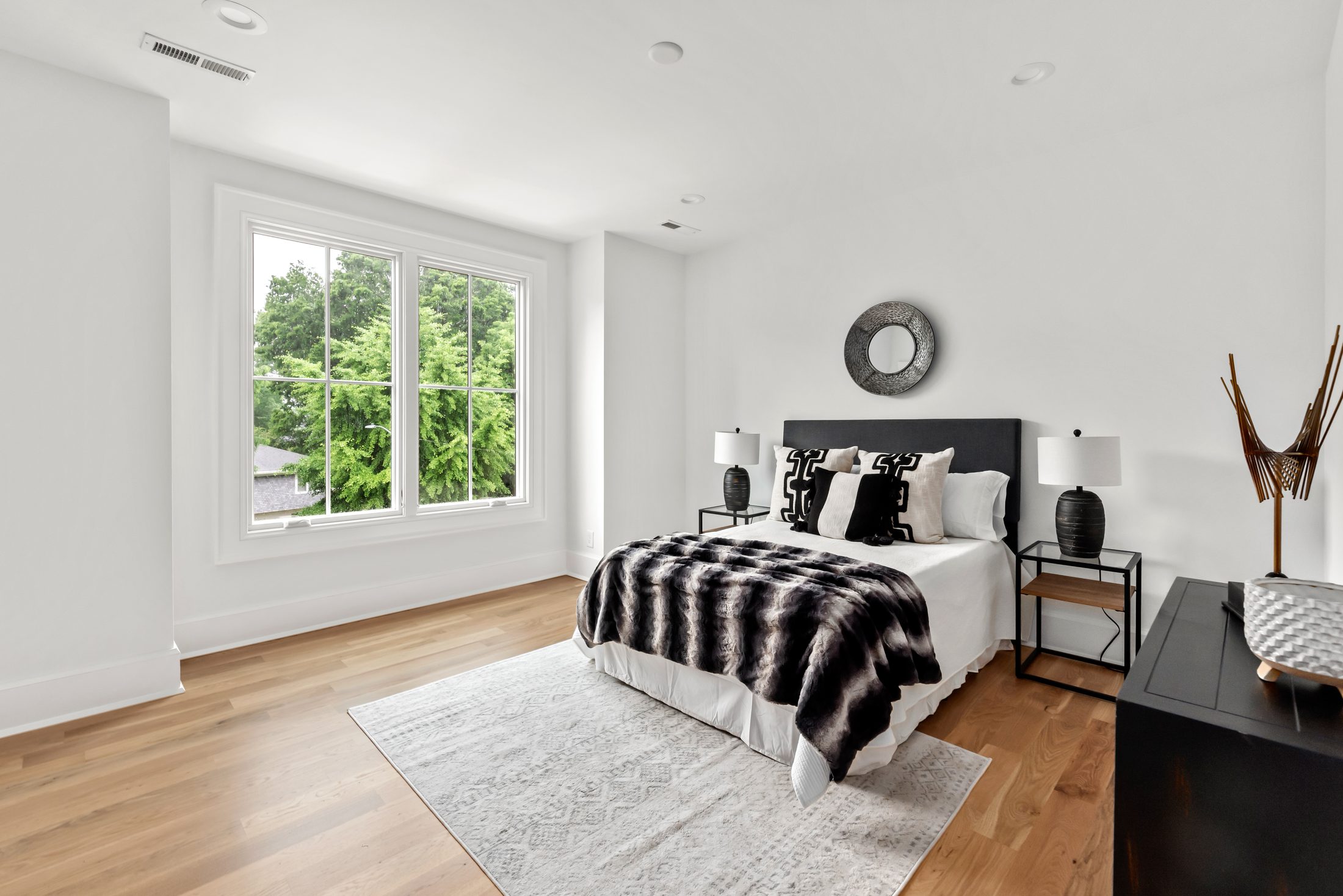 Secondary bedroom with black upholstered bed and layered neutral textures — Bywood by Stillman Properties Charlotte NC
