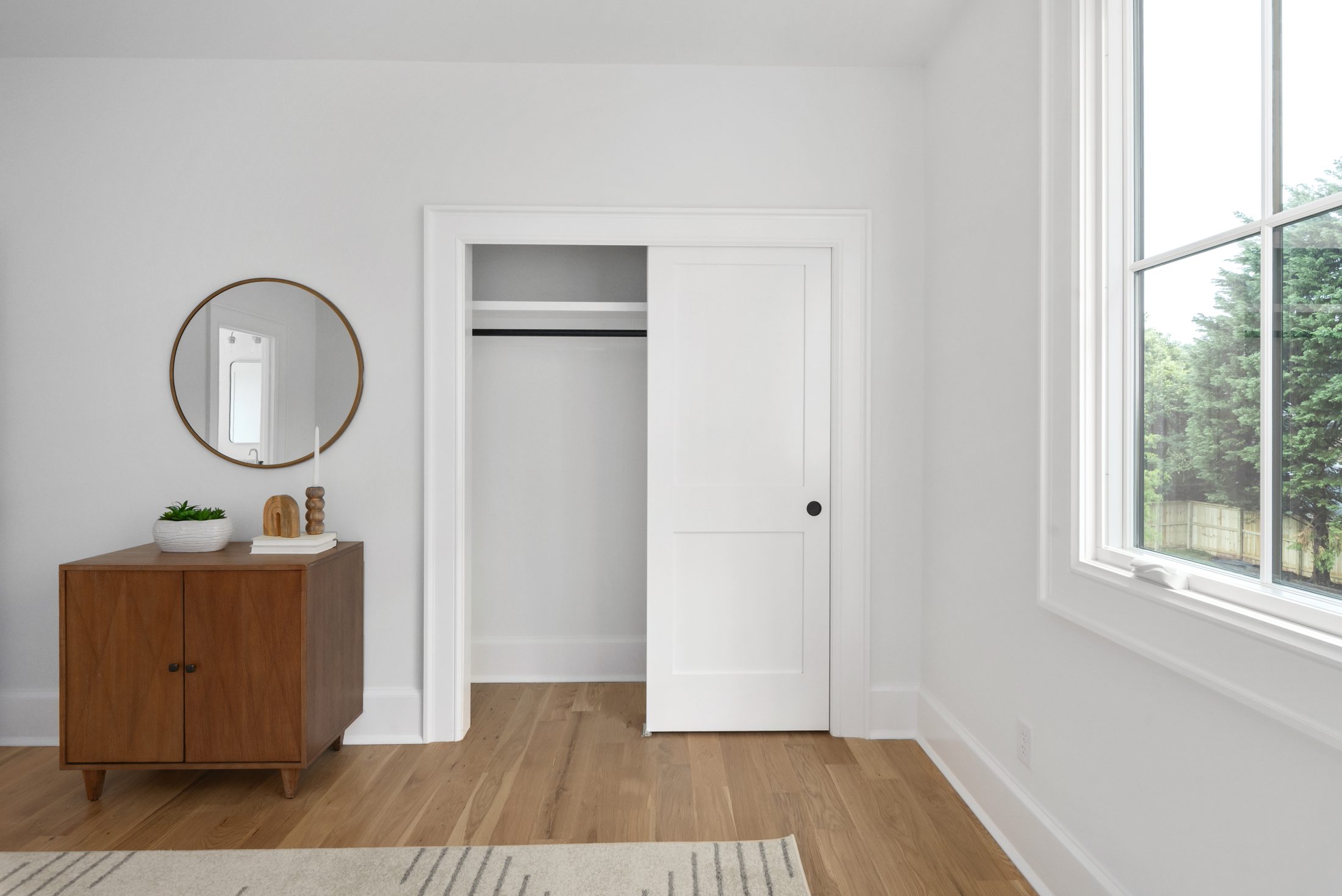 Secondary bedroom with sliding-door closet and white oak floors — Bywood by Stillman Properties Charlotte NC