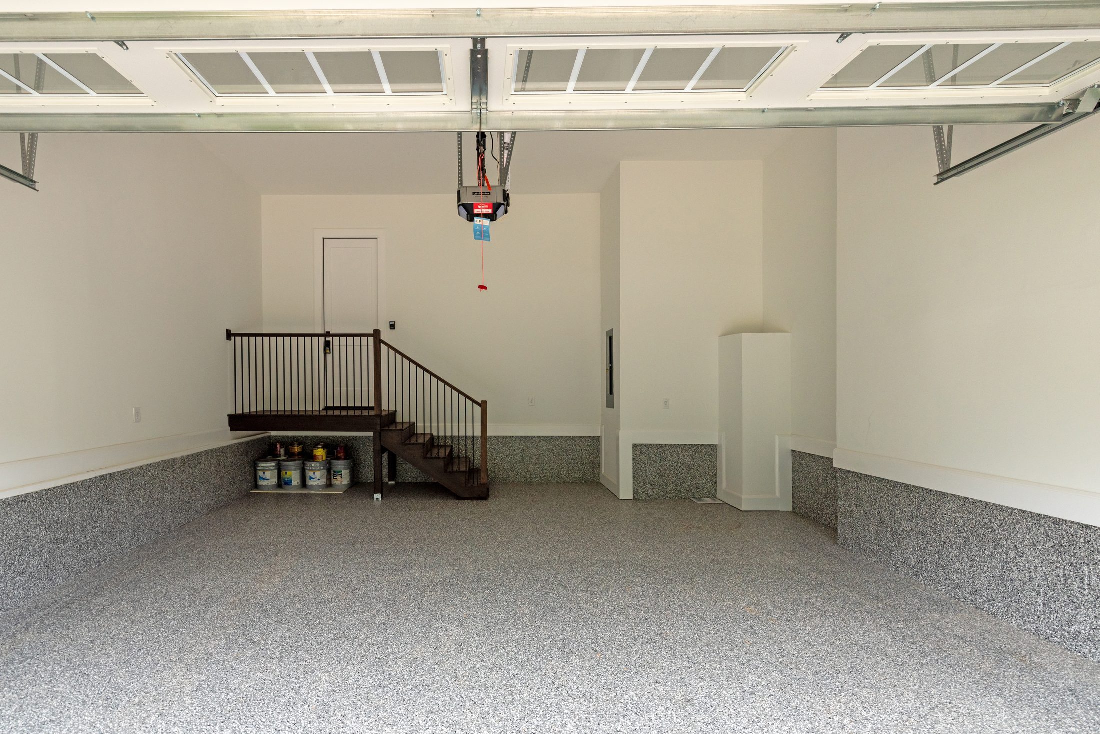 Finished garage from an alternate angle showing epoxy-flake floor and glass-panel garage door — Bywood by Stillman Properties Charlotte NC