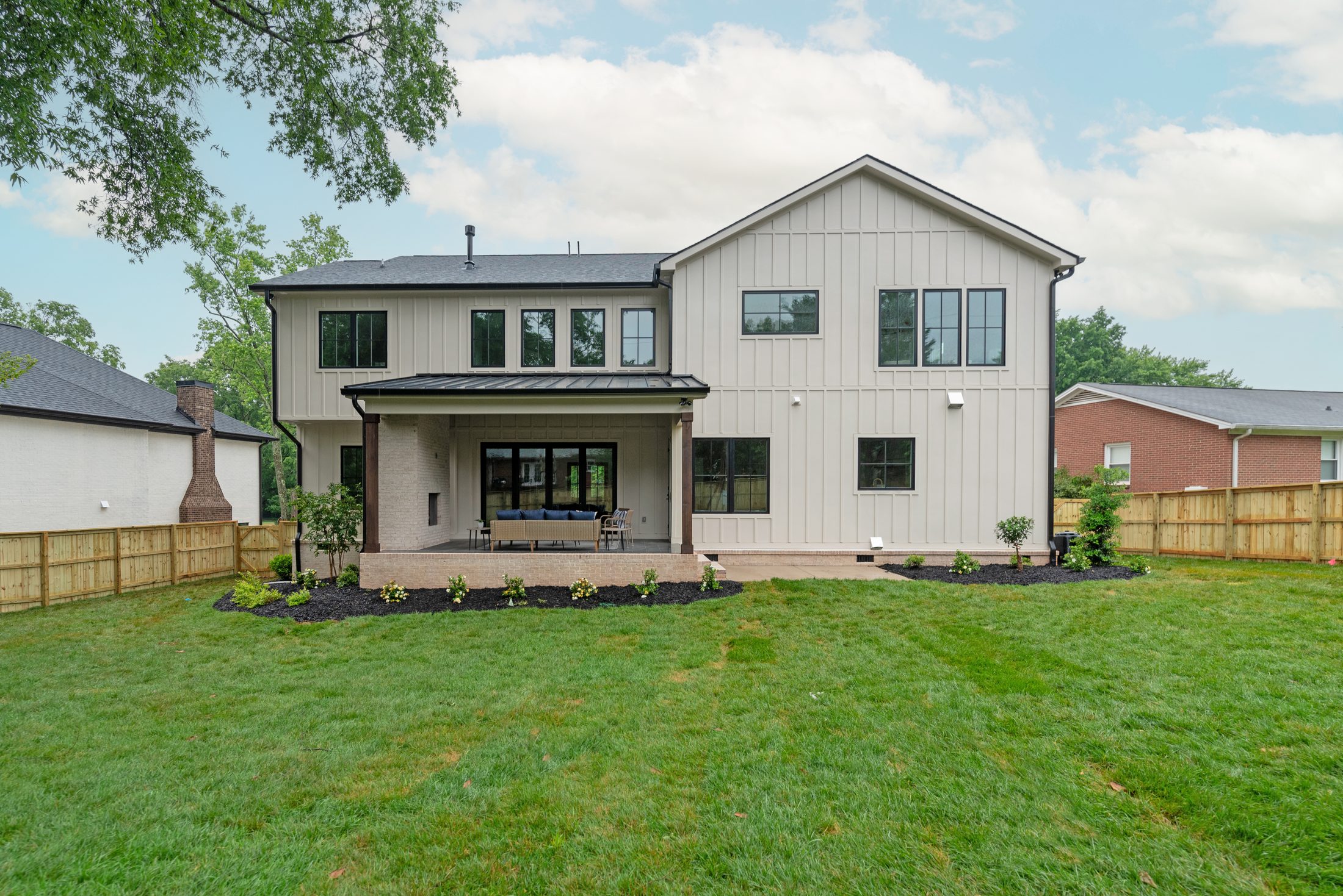 Rear elevation of Bywood showing the covered porch, board-and-batten siding, and full two-story rear — Stillman Properties Charlotte NC
