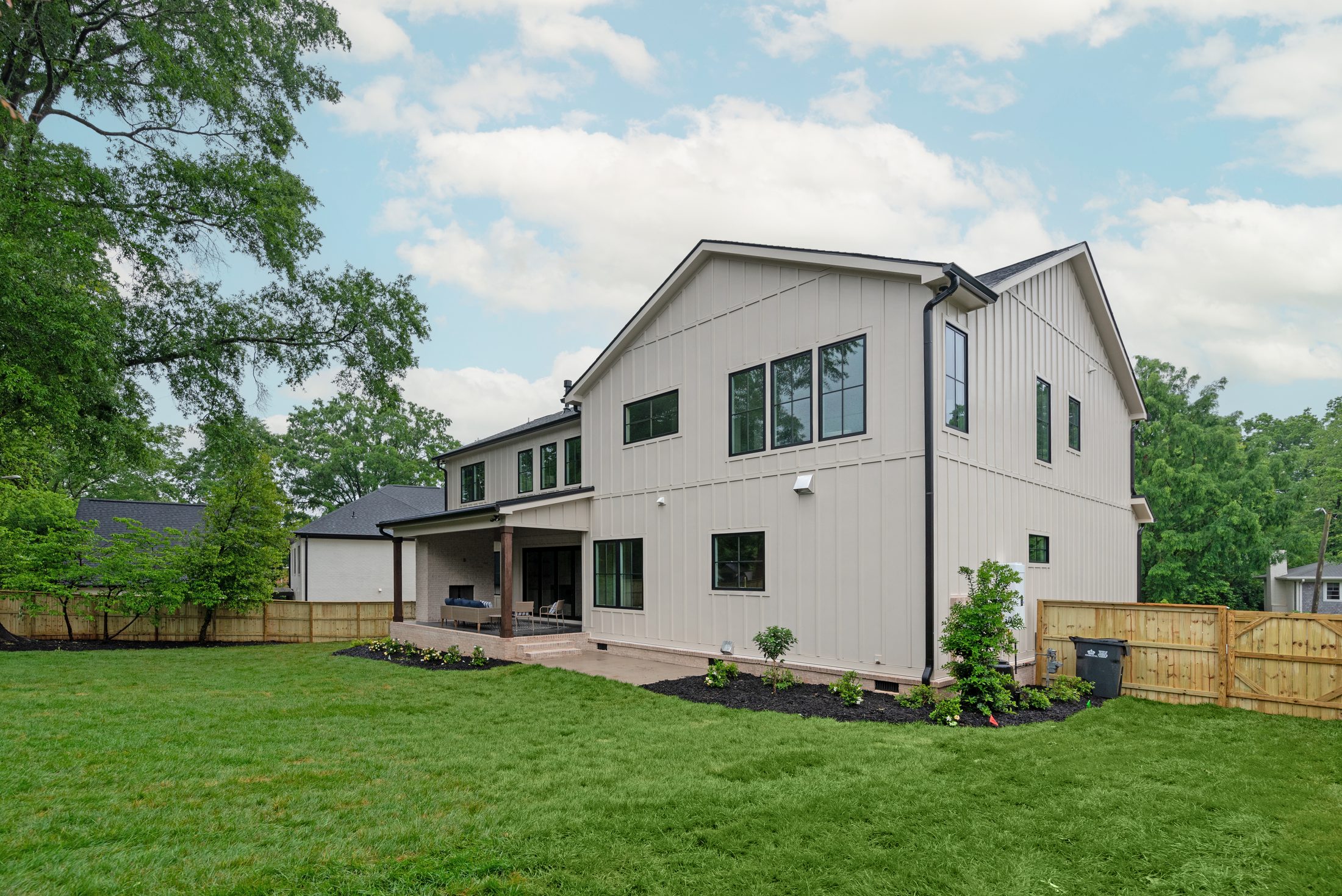 Three-quarter rear view of Bywood with covered outdoor living and fenced yard — Stillman Properties Charlotte NC