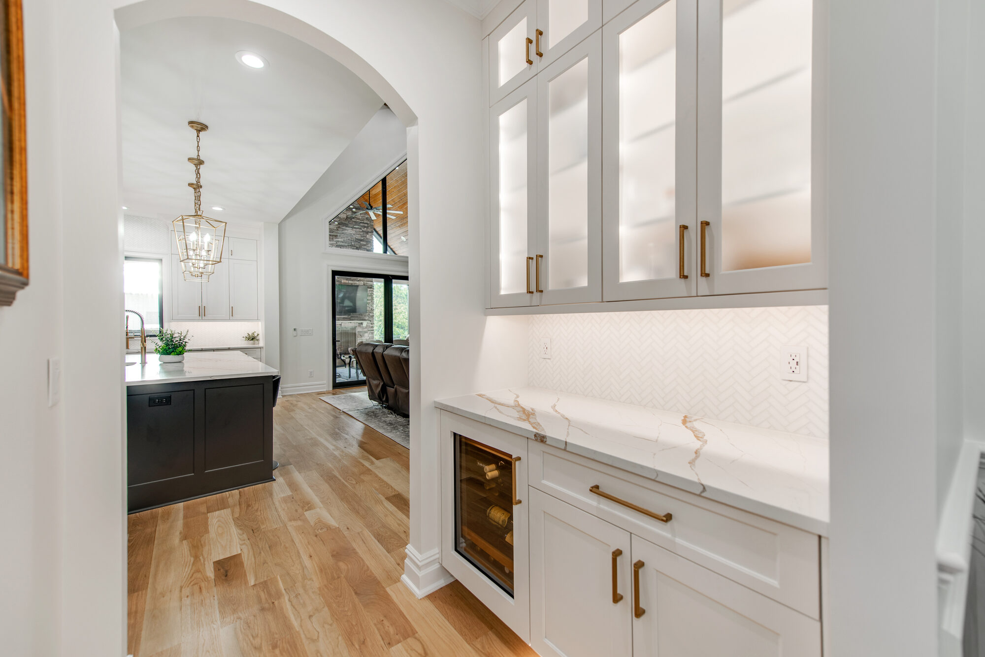 Butler's pantry with calacatta countertops, herringbone backsplash, wine refrigerator, and sightline to the kitchen — Coddle Creek by Stillman Properties Concord NC