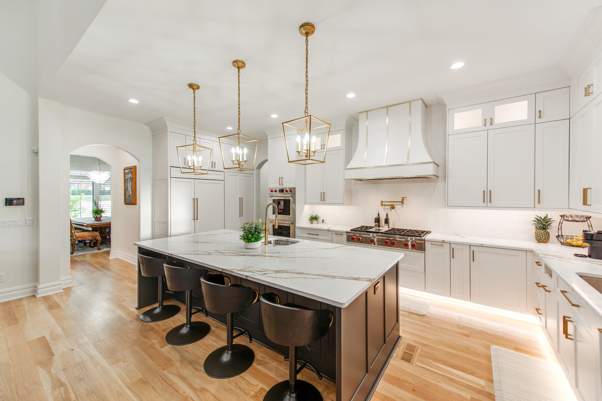 Kitchen alternate view showing Wolf range, custom hood with brass strapping, and pot filler — Coddle Creek by Stillman Properties Concord NC