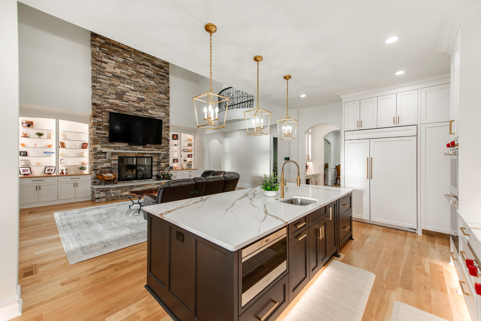 Kitchen island looking back toward the great room with stone fireplace and juliet balcony — Coddle Creek by Stillman Properties Concord NC