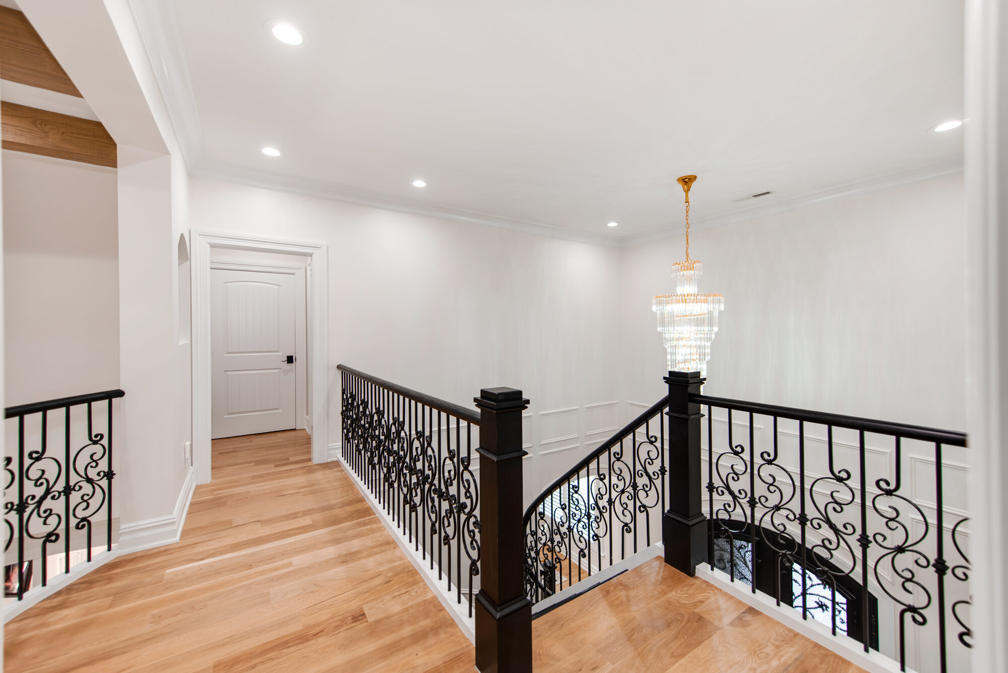 Upstairs landing with iron scrollwork railings and crystal pendant — Coddle Creek by Stillman Properties Concord NC