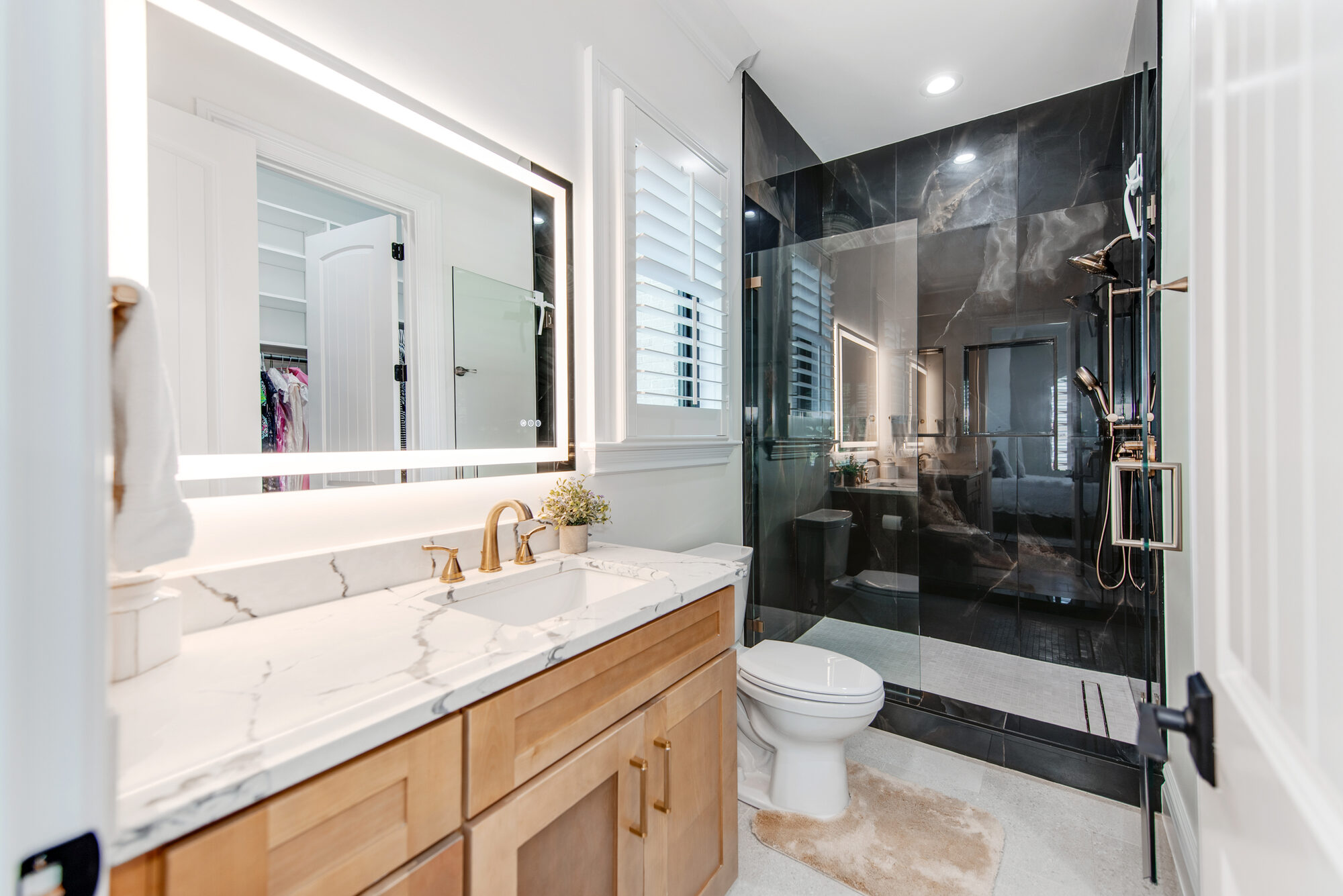Guest bath with dramatic dark stone walk-in shower and brushed brass fixtures — Coddle Creek by Stillman Properties Concord NC