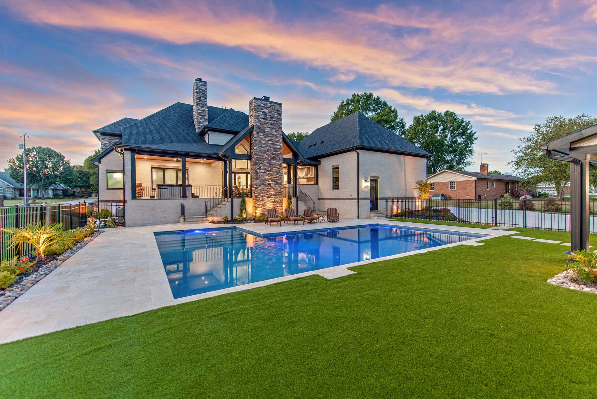 Coddle Creek estate at dusk with home aglow, pool reflecting the sunset sky — Stillman Properties Concord NC