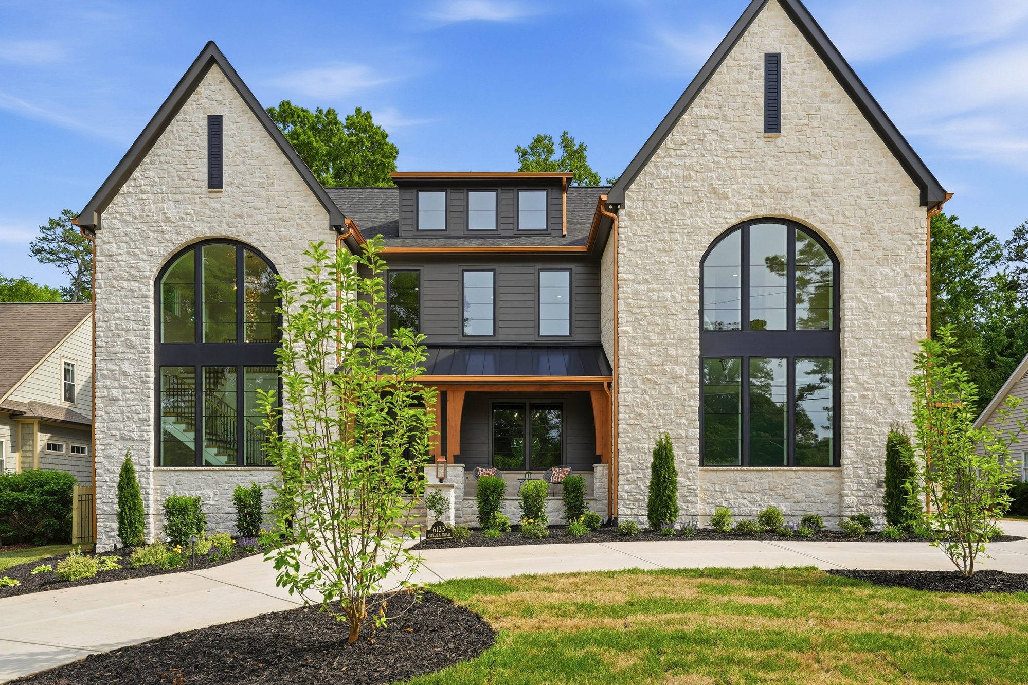 Front elevation detail showing limestone, copper trim, and arched window walls — Creola custom home in Charlotte NC by Stillman Properties