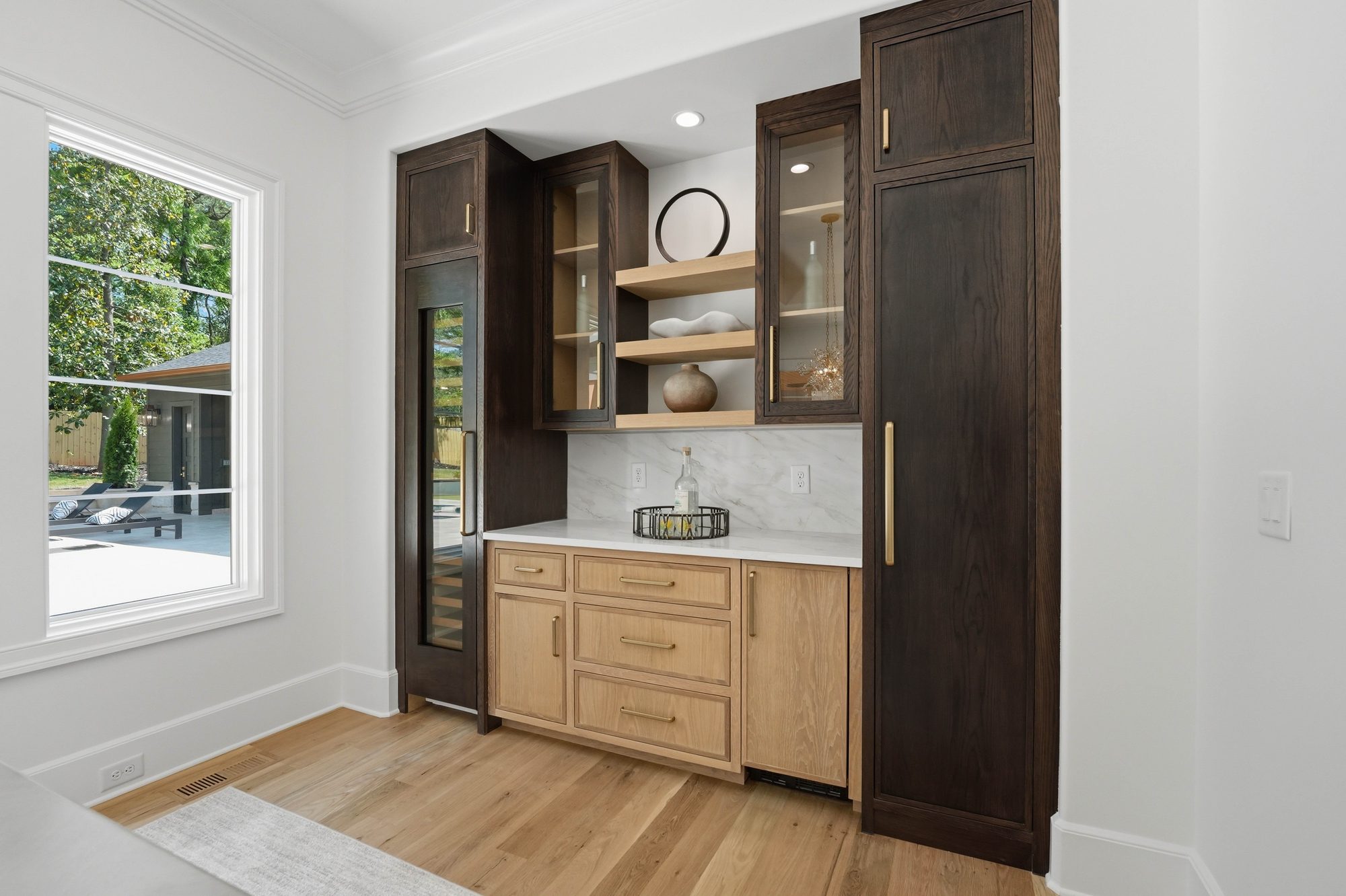 Adjacent butler's pantry and wine bar with walnut and white oak cabinetry — Creola custom home in Charlotte NC by Stillman Properties