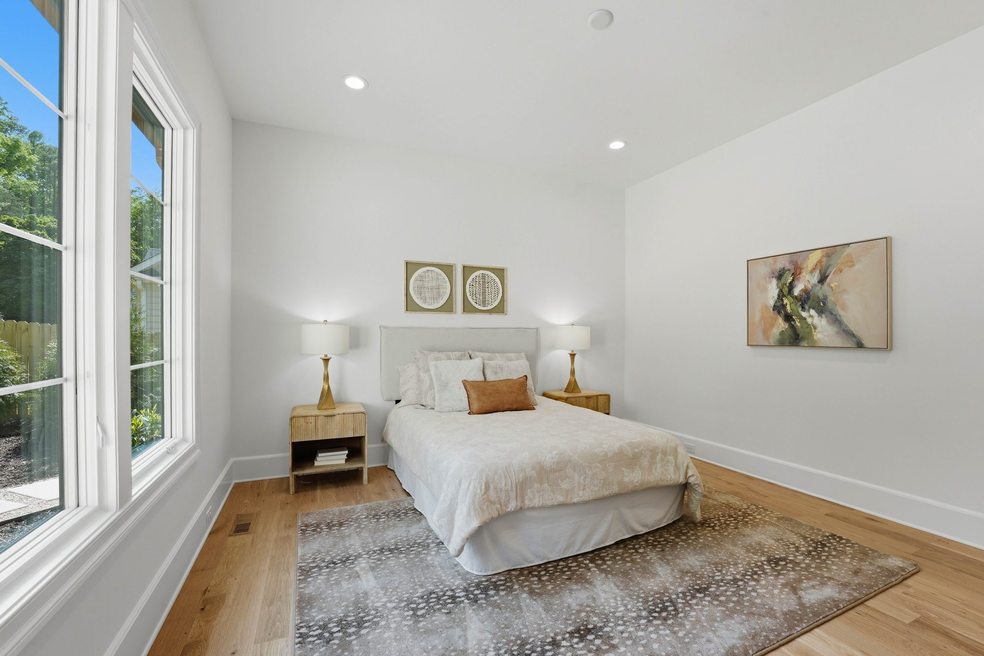 Light-filled guest bedroom with white oak floors and abstract artwork — Creola custom home in Charlotte NC by Stillman Properties