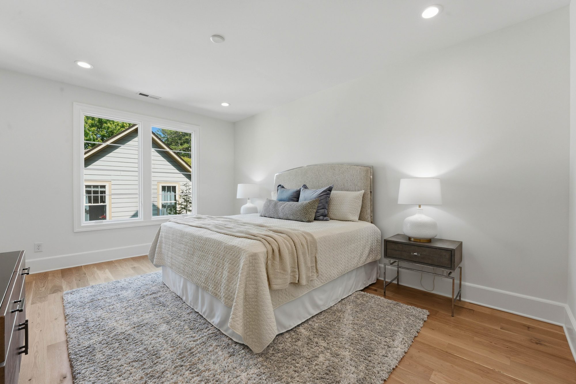 Bright guest bedroom with neutral palette and tree-top views — Creola custom home in Charlotte NC by Stillman Properties
