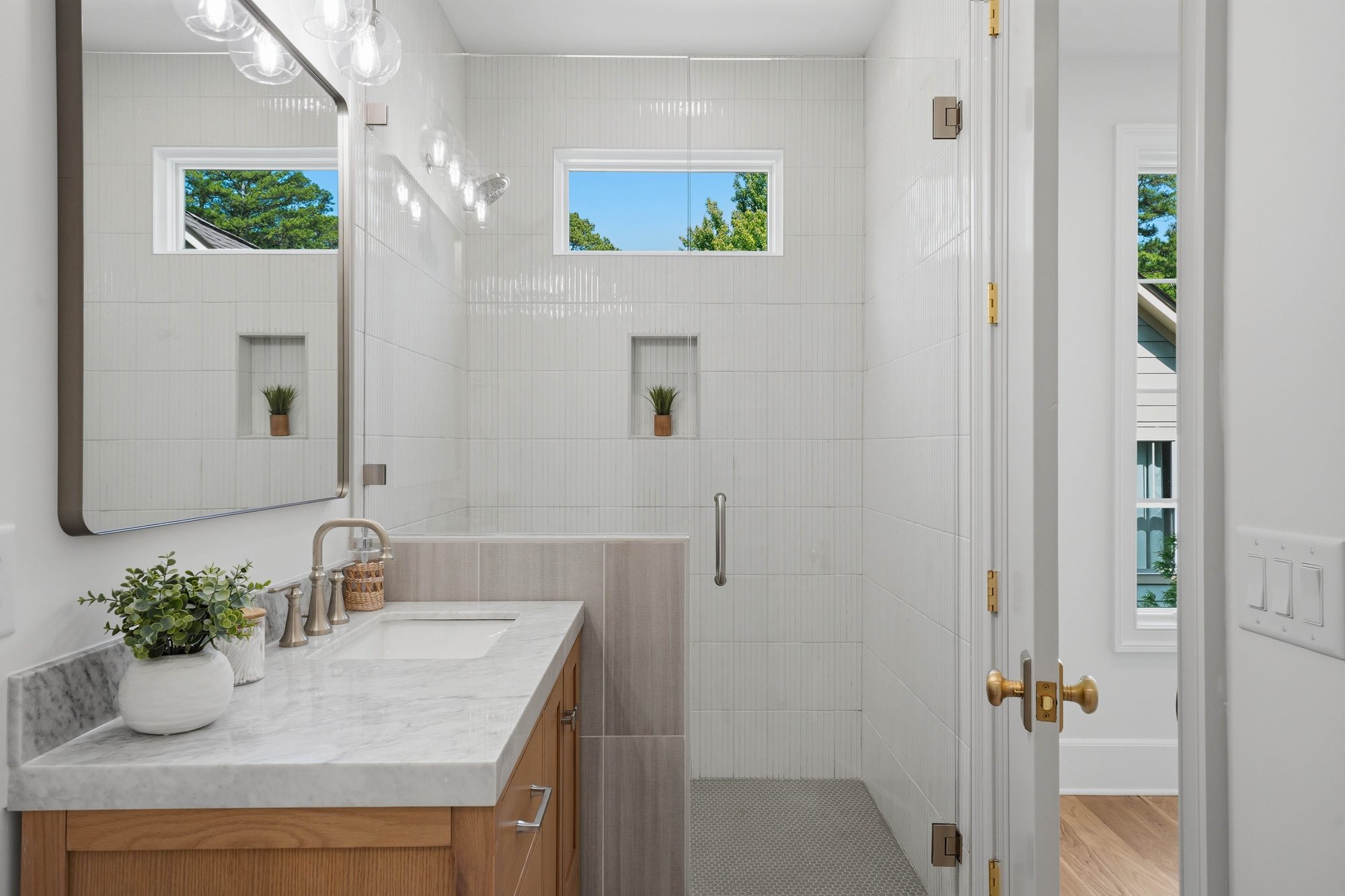 Guest bath with vertical white tile and marble-topped oak vanity — Creola custom home in Charlotte NC by Stillman Properties