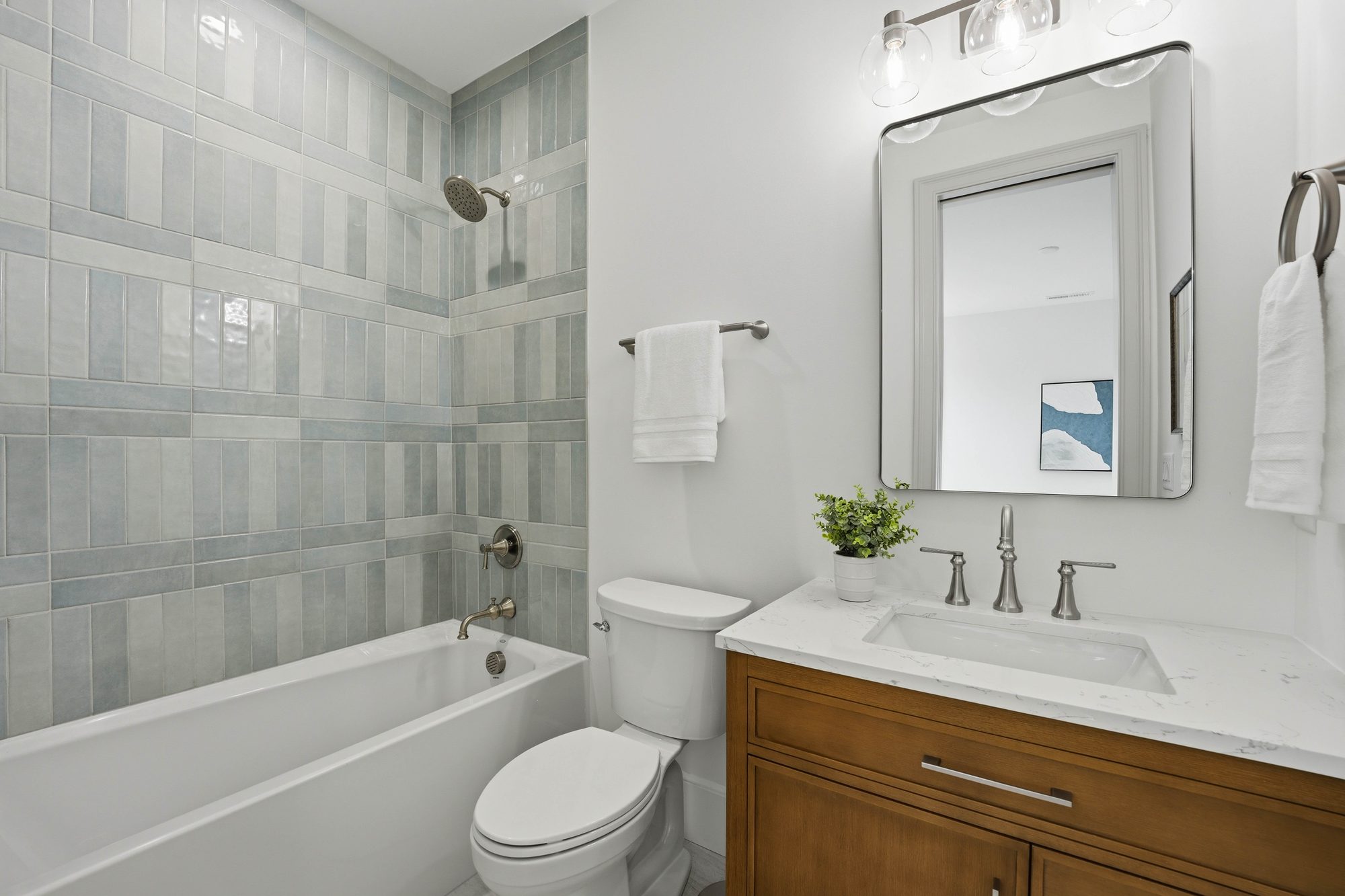 Guest bath with soaking tub, blue glazed tile surround, and oak vanity — Creola custom home in Charlotte NC by Stillman Properties