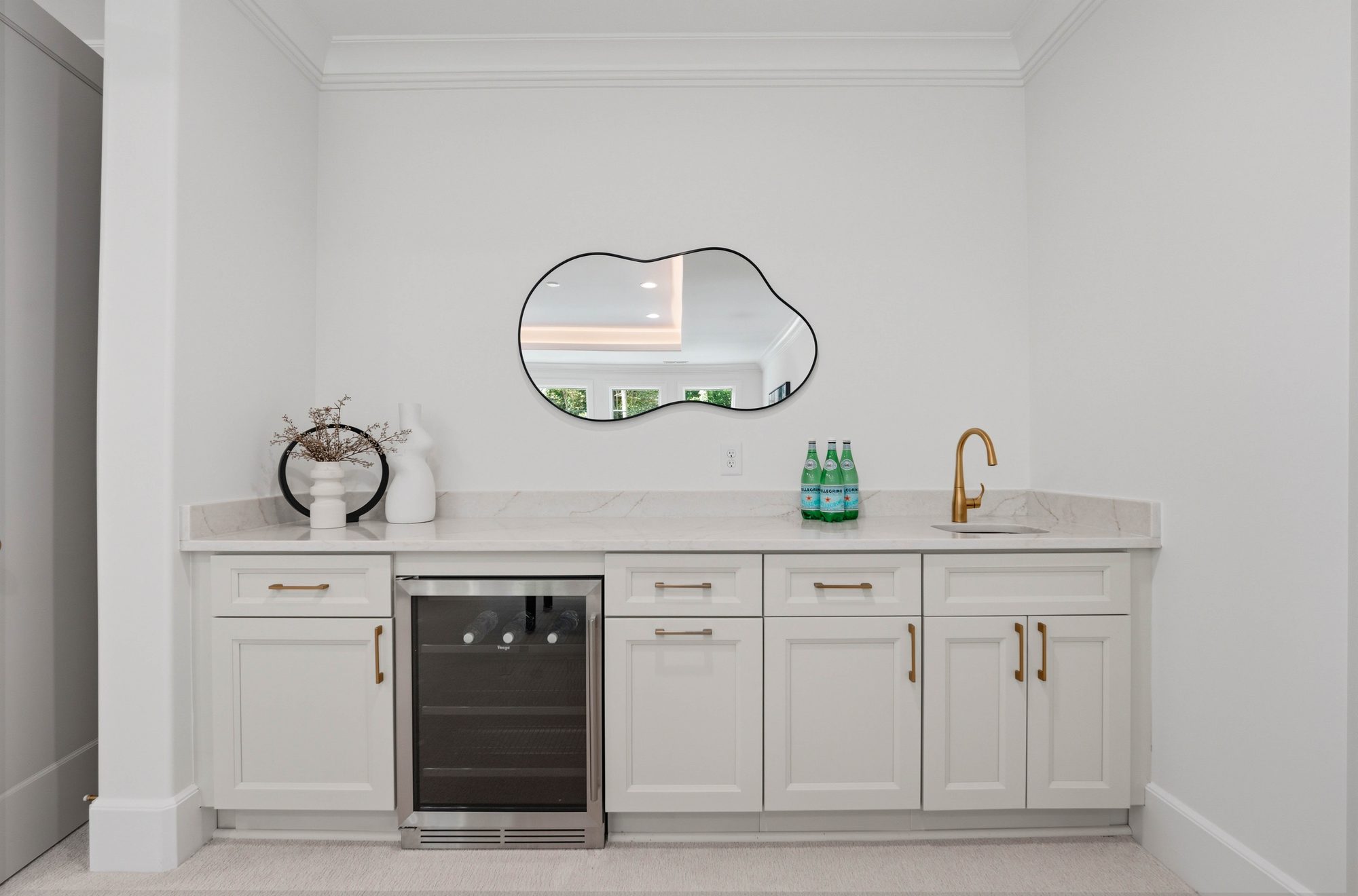 Bonus room wet bar with beverage refrigerator and sculptural mirror — Creola custom home in Charlotte NC by Stillman Properties