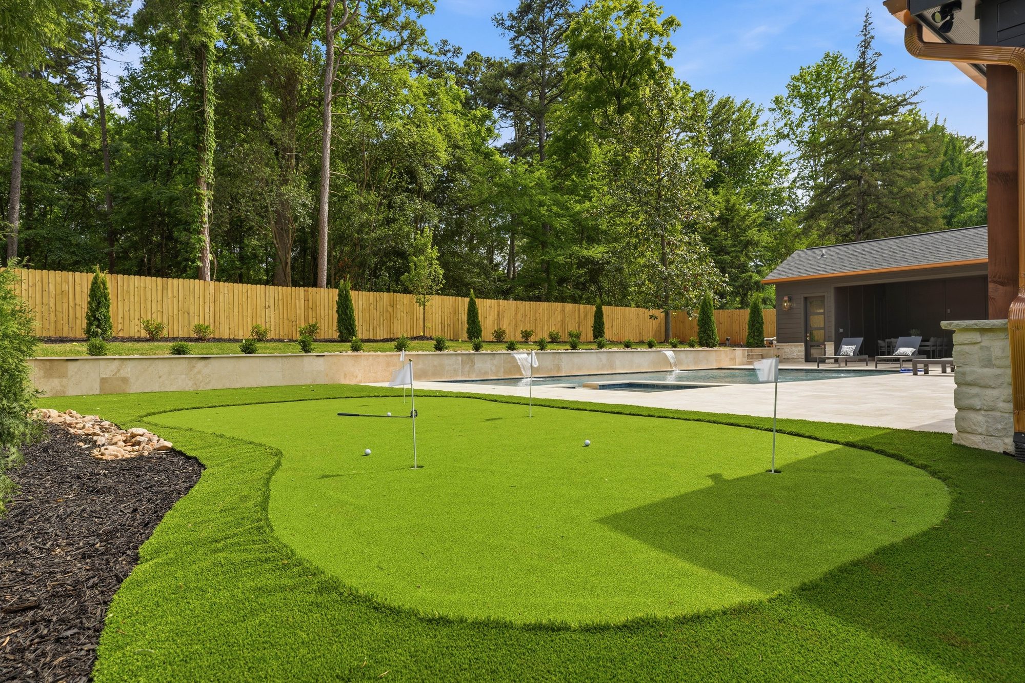 Backyard putting green with artificial turf and stone surround — Creola custom home in Charlotte NC by Stillman Properties