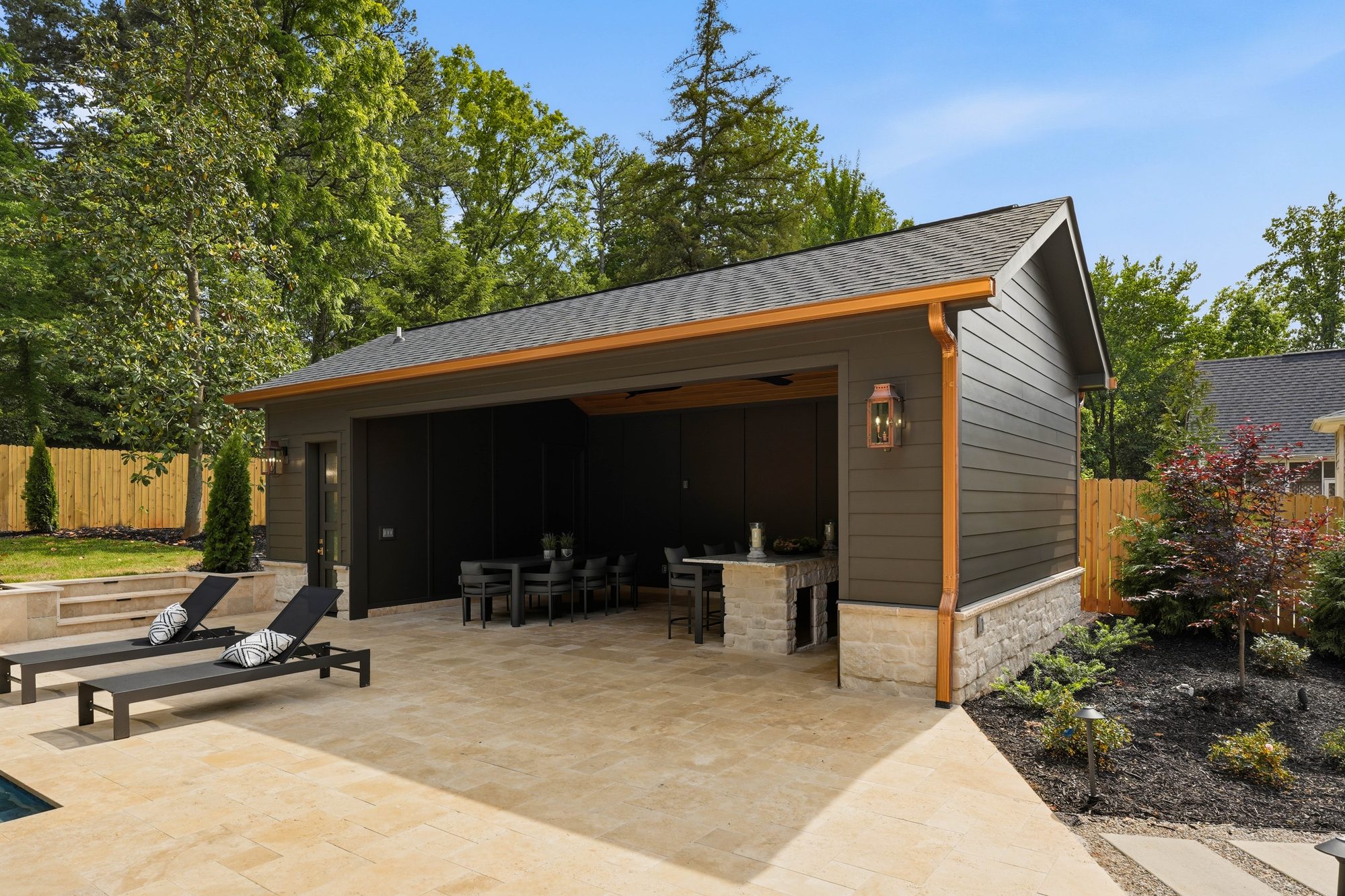 Detached pool cabana with copper trim, sliding doors, and adjacent travertine deck — Creola custom home in Charlotte NC by Stillman Properties