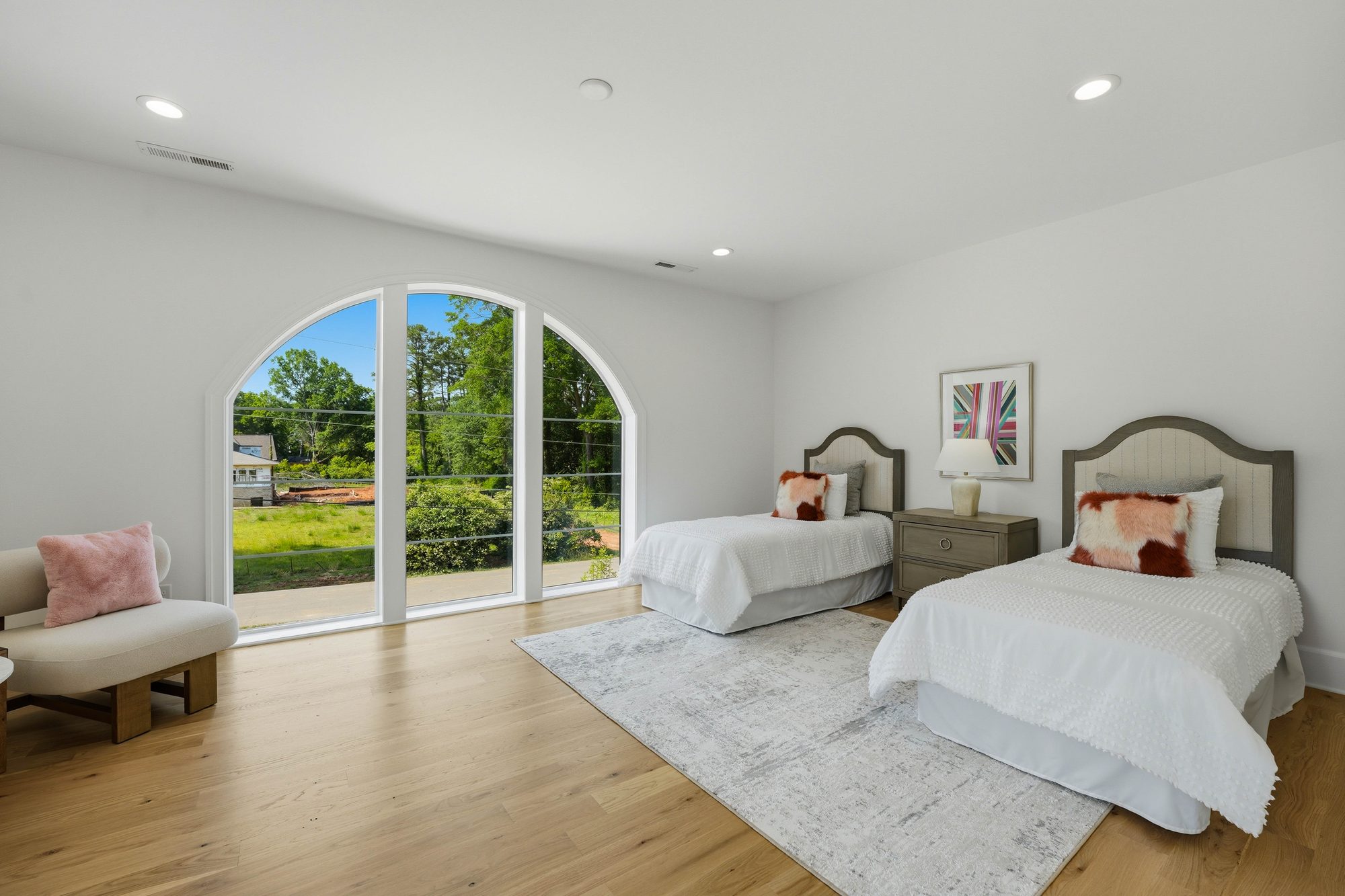 Twin-bed guest room framed by a cathedral-arched front window with garden views — Creola custom home in Charlotte NC by Stillman Properties