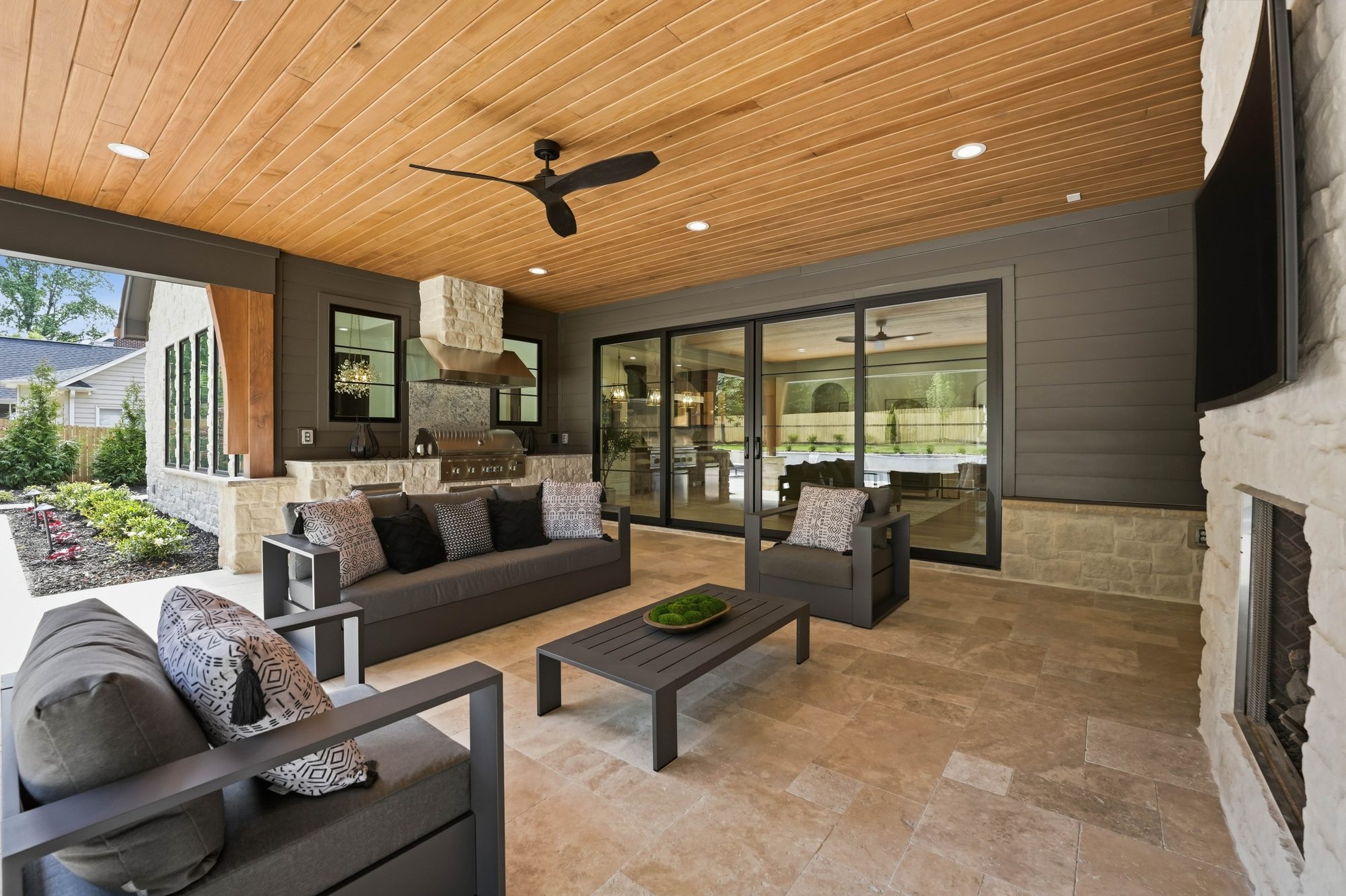 Covered outdoor living looking out through retractable walls to the pool — Creola custom home in Charlotte NC by Stillman Properties