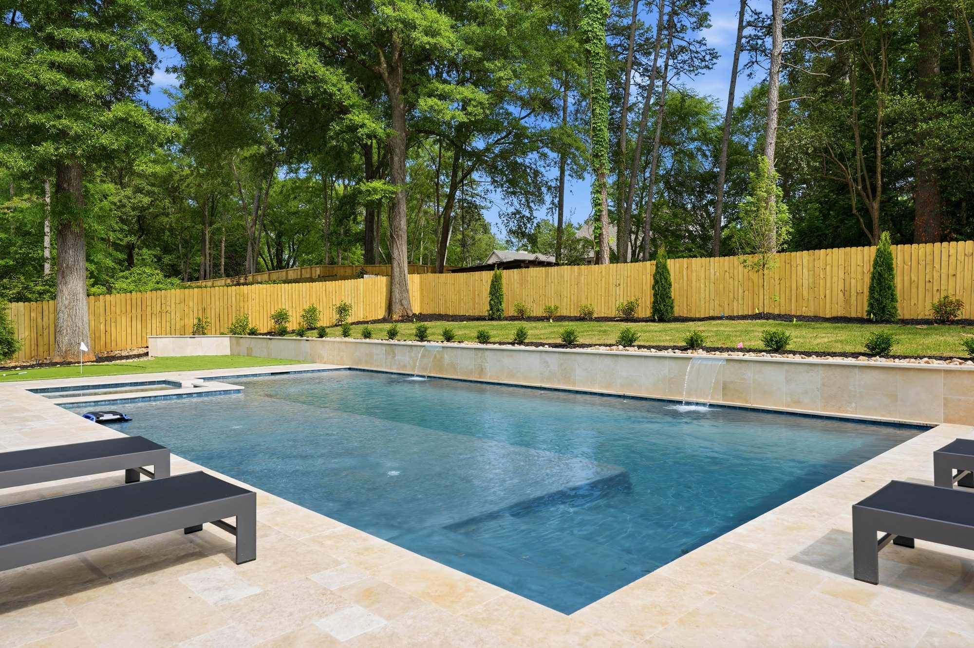 Pool with chaise loungers along the travertine deck — Creola custom home in Charlotte NC by Stillman Properties