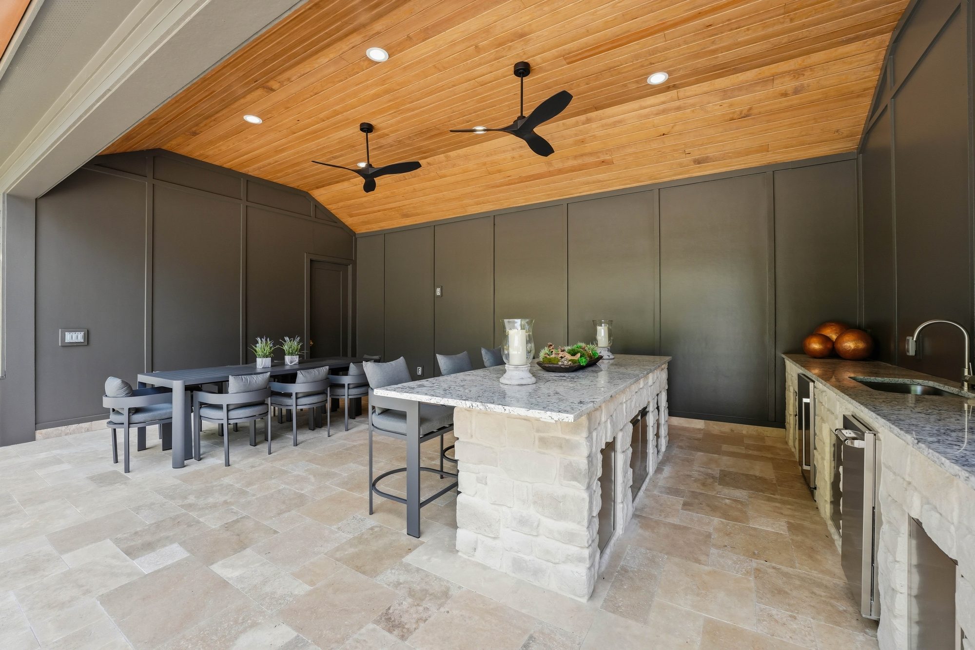 Pool cabana interior with stone-clad island, vaulted cedar ceiling, and bar service — Creola custom home in Charlotte NC by Stillman Properties