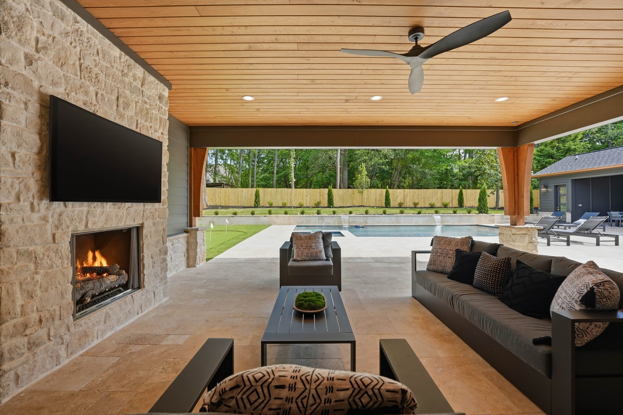 Outdoor living sectional with stone fireplace and built-in television — Creola custom home in Charlotte NC by Stillman Properties