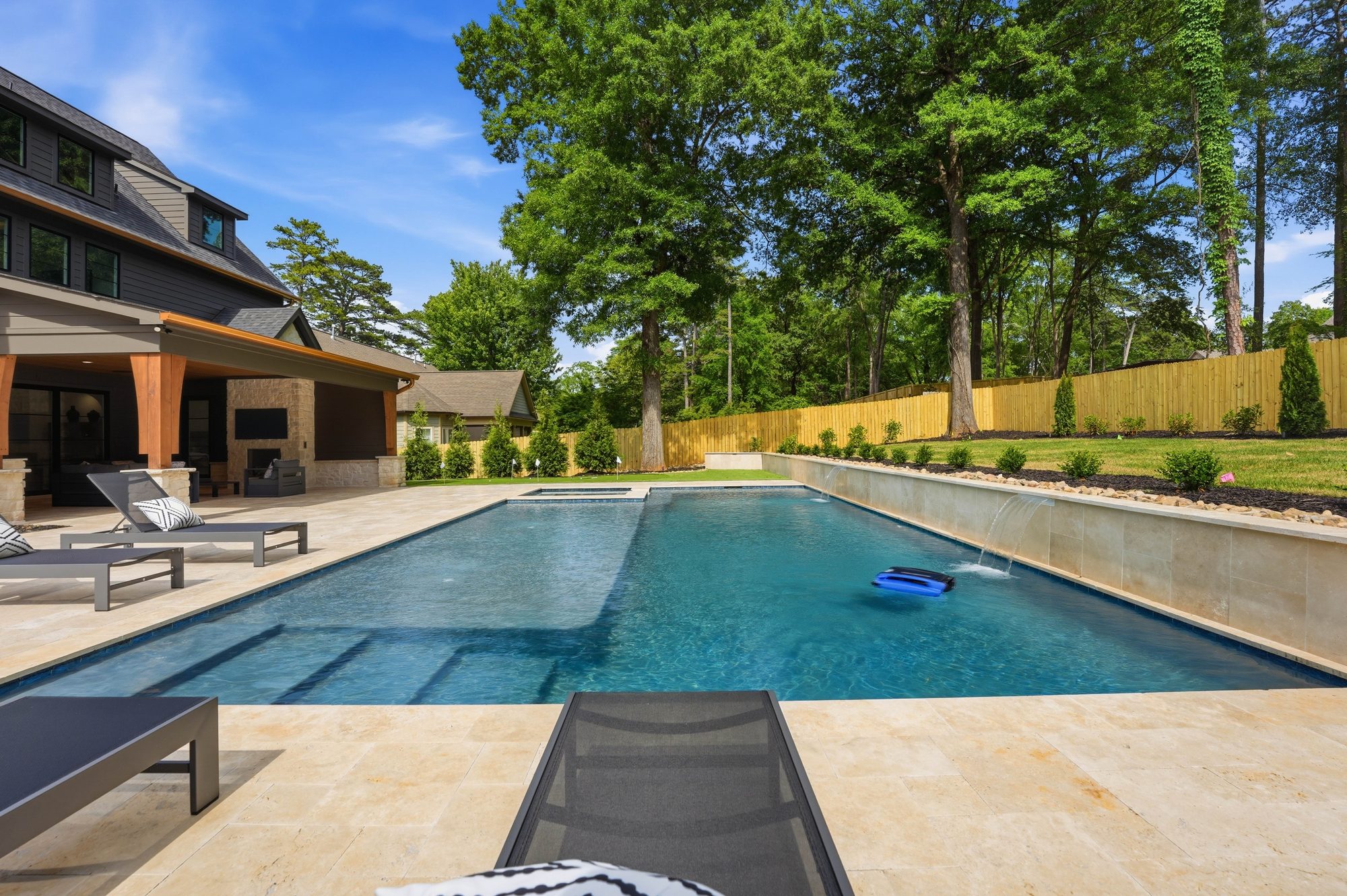 Pool and travertine deck with the main house and outdoor living wing as backdrop — Creola custom home in Charlotte NC by Stillman Properties
