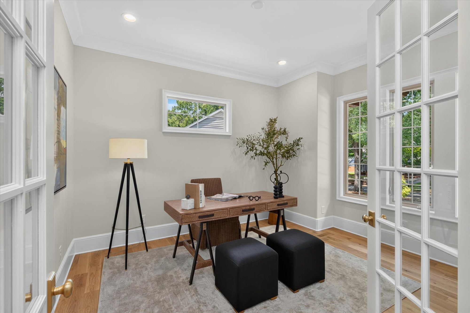 Main-level guest room and office at Heather behind divided-light French doors, with crown molding and a transom window — Heather by Stillman Properties Charlotte NC
