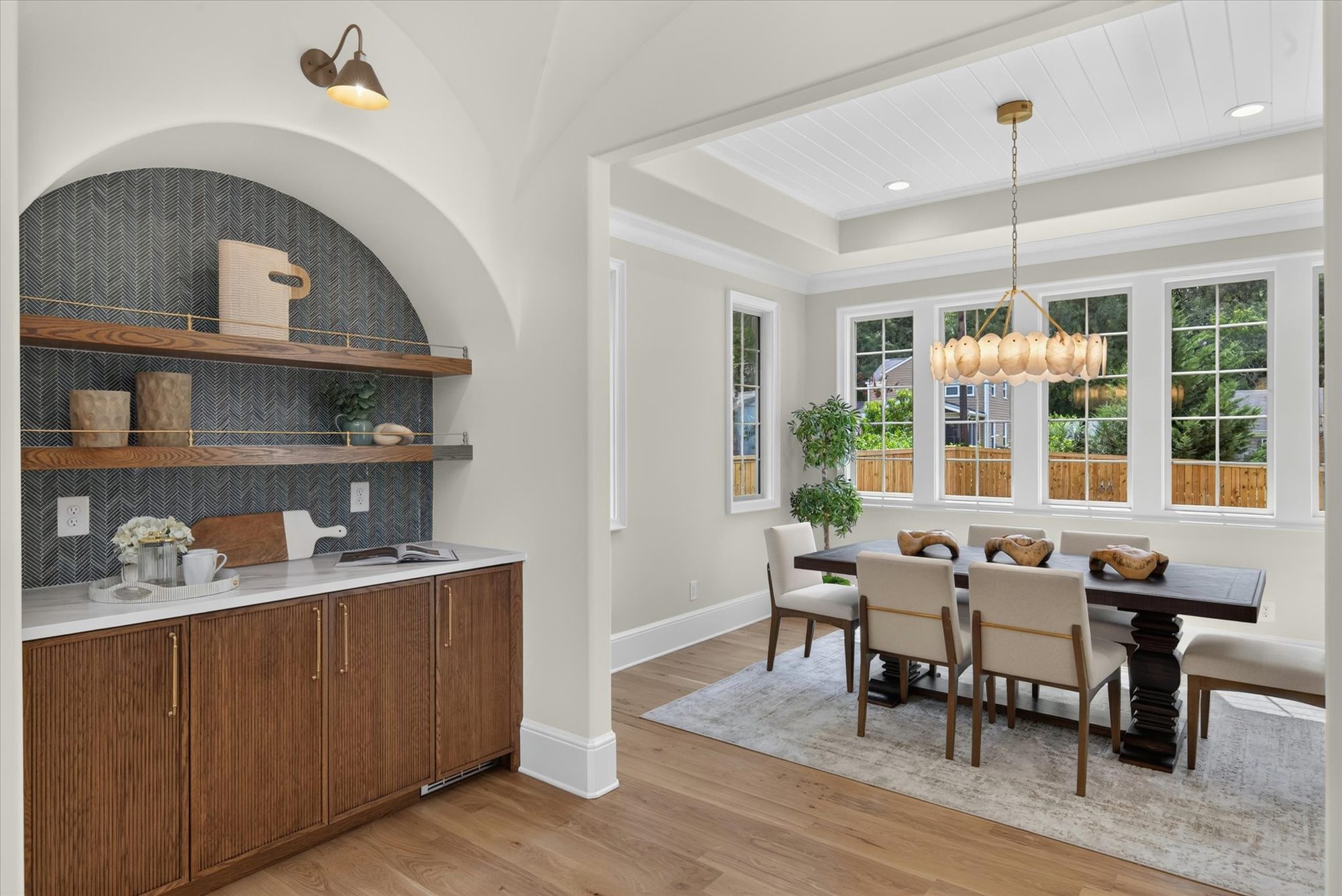 Groin-vaulted coffee bar alcove at Heather with dark herringbone tile, oak floating shelves on brass rails, and fluted cabinetry — Heather by Stillman Properties Charlotte NC