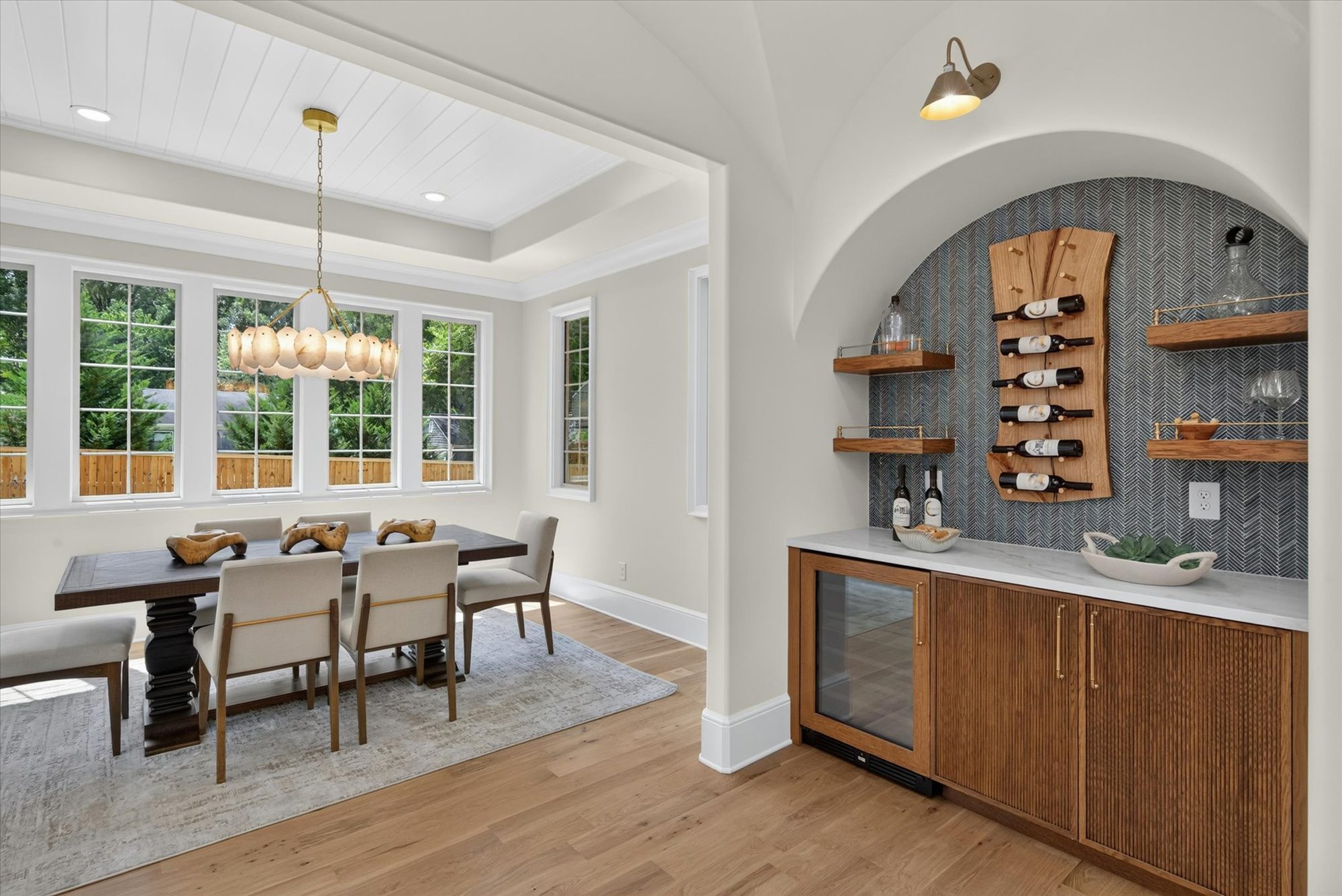 Wine wall at Heather with live-edge bottle rack set into a herringbone-tiled arch beside the dining room — Heather by Stillman Properties Charlotte NC