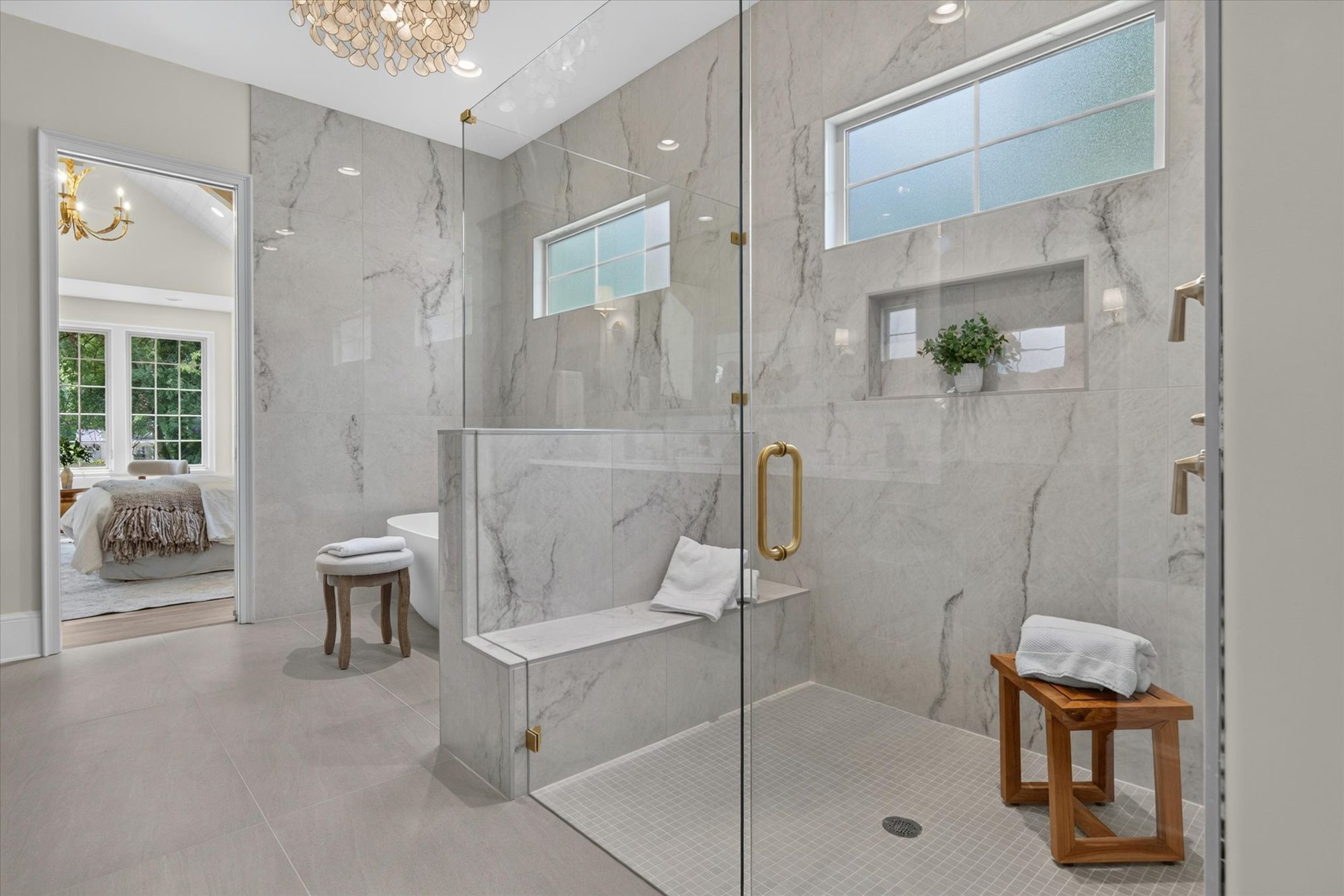 Walk-in marble shower at Heather with built-in bench, brass fittings, and dual shower heads — Heather by Stillman Properties Charlotte NC