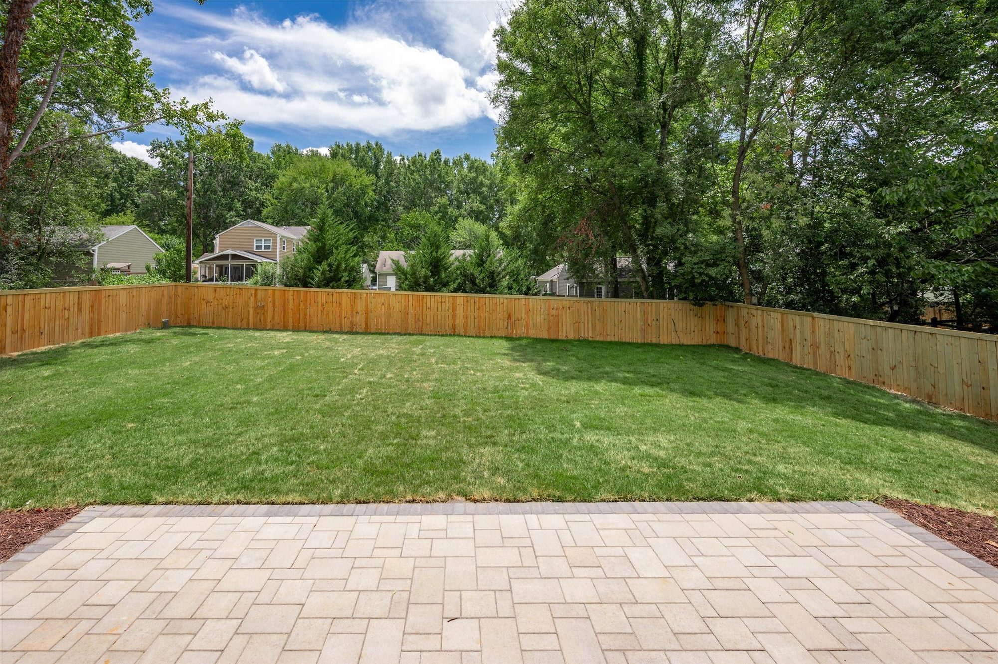 Paver terrace and fenced rear lawn at Heather backing to mature trees — Heather by Stillman Properties Charlotte NC