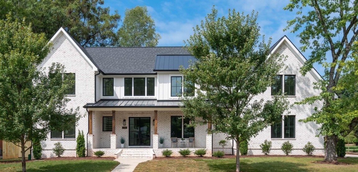 Walker transitional custom home in Cotswold Charlotte NC by Stillman Properties — whitewashed brick exterior with twin gables