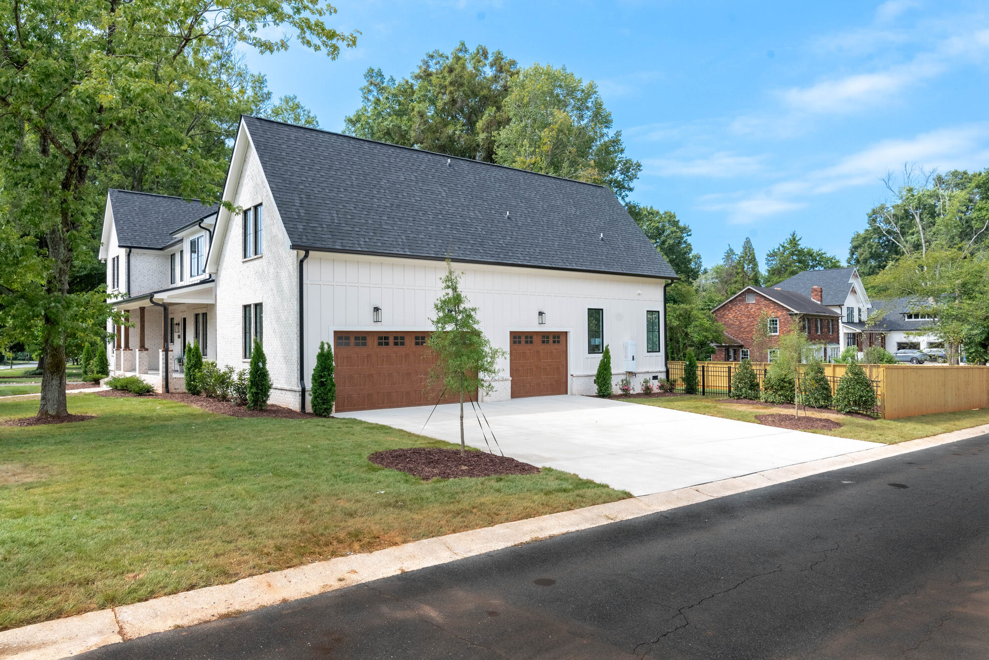 Walker side elevation showing the front porch and detached carriage-style garage doors — Stillman Properties Cotswold Charlotte NC