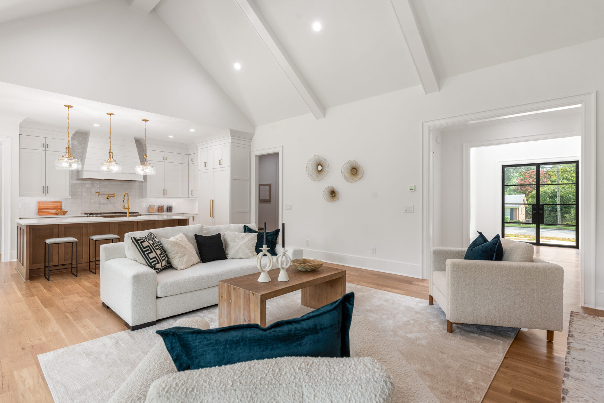 Walker great room looking toward the chef's kitchen with brass pendant lighting — Stillman Properties Cotswold Charlotte NC