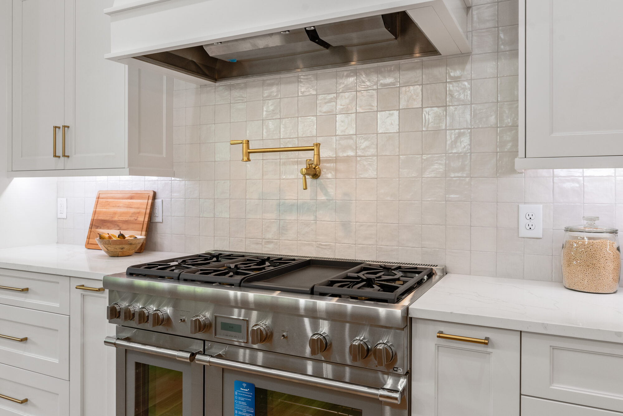 Walker Wolf gas range detail with brass pot filler and zellige-style backsplash tile — Stillman Properties Cotswold Charlotte NC