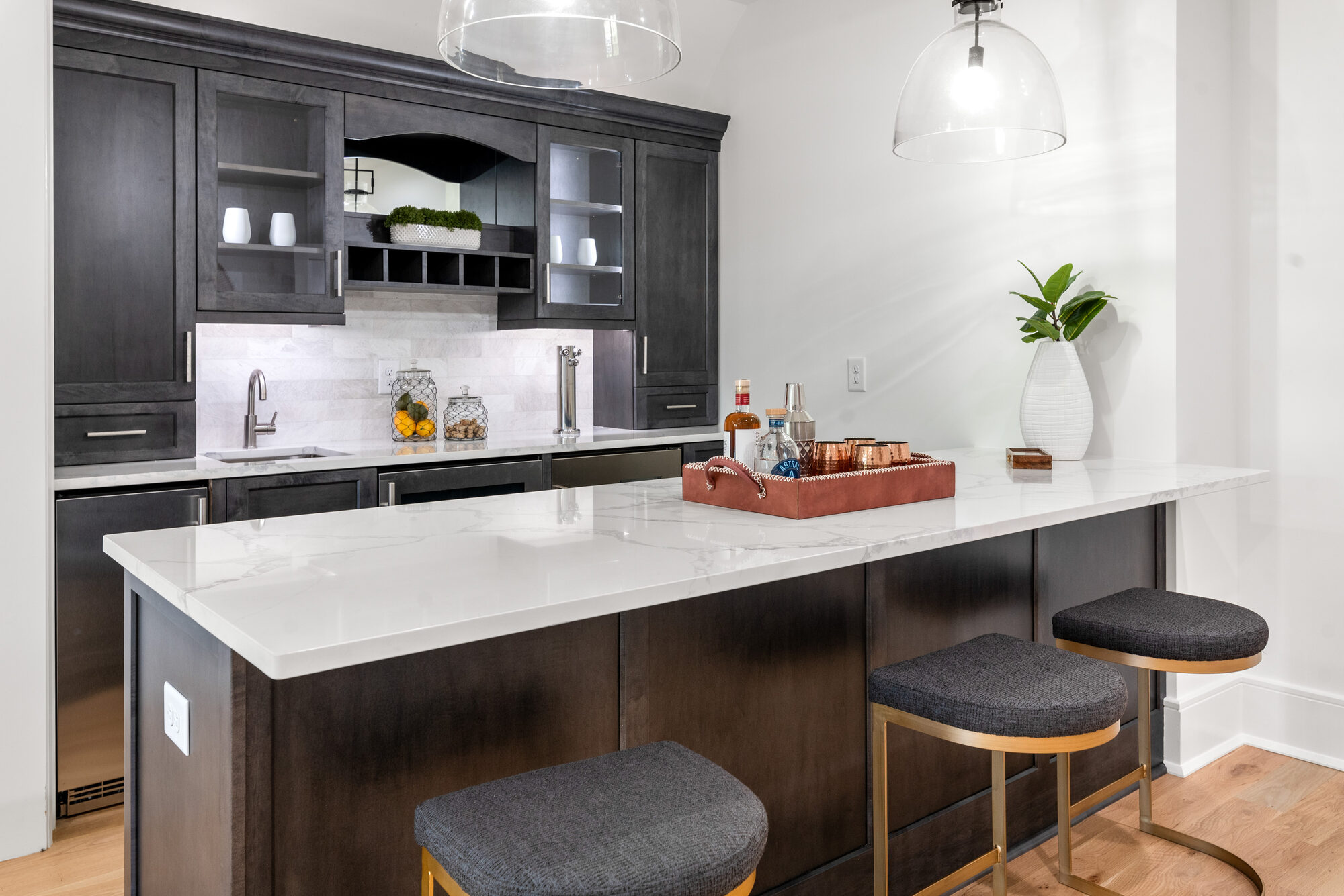 Walker upstairs wet bar with espresso cabinetry, marble counter, kegerator tap, and glass-fronted display cabinets — Stillman Properties Cotswold Charlotte NC