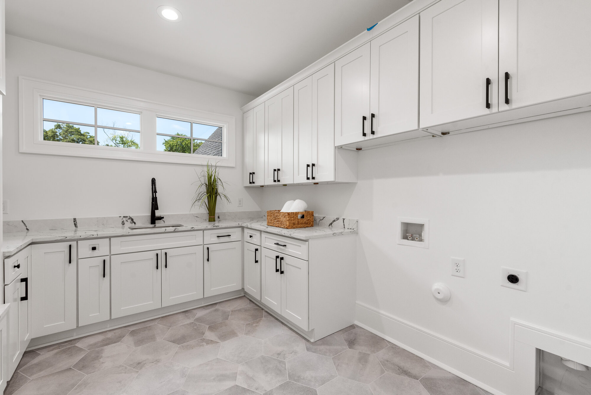 Walker laundry room with quartz countertops, hexagon tile floor, and integrated dog door — Stillman Properties Cotswold Charlotte NC