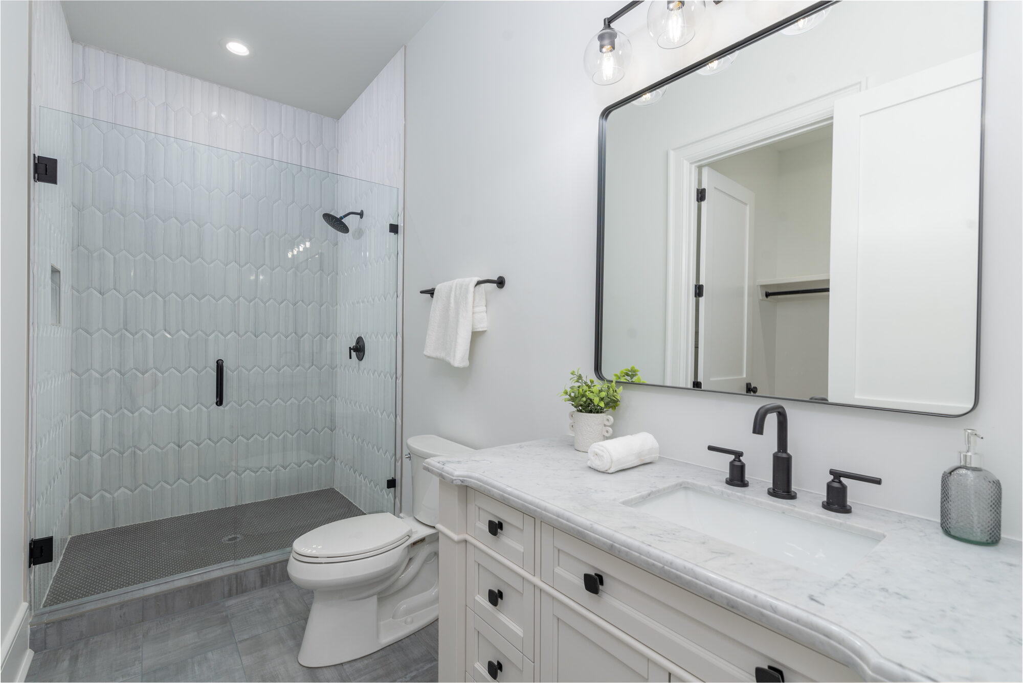 Walker guest bath with picket-tile shower, white shaker vanity, and matte black fixtures — Stillman Properties Cotswold Charlotte NC