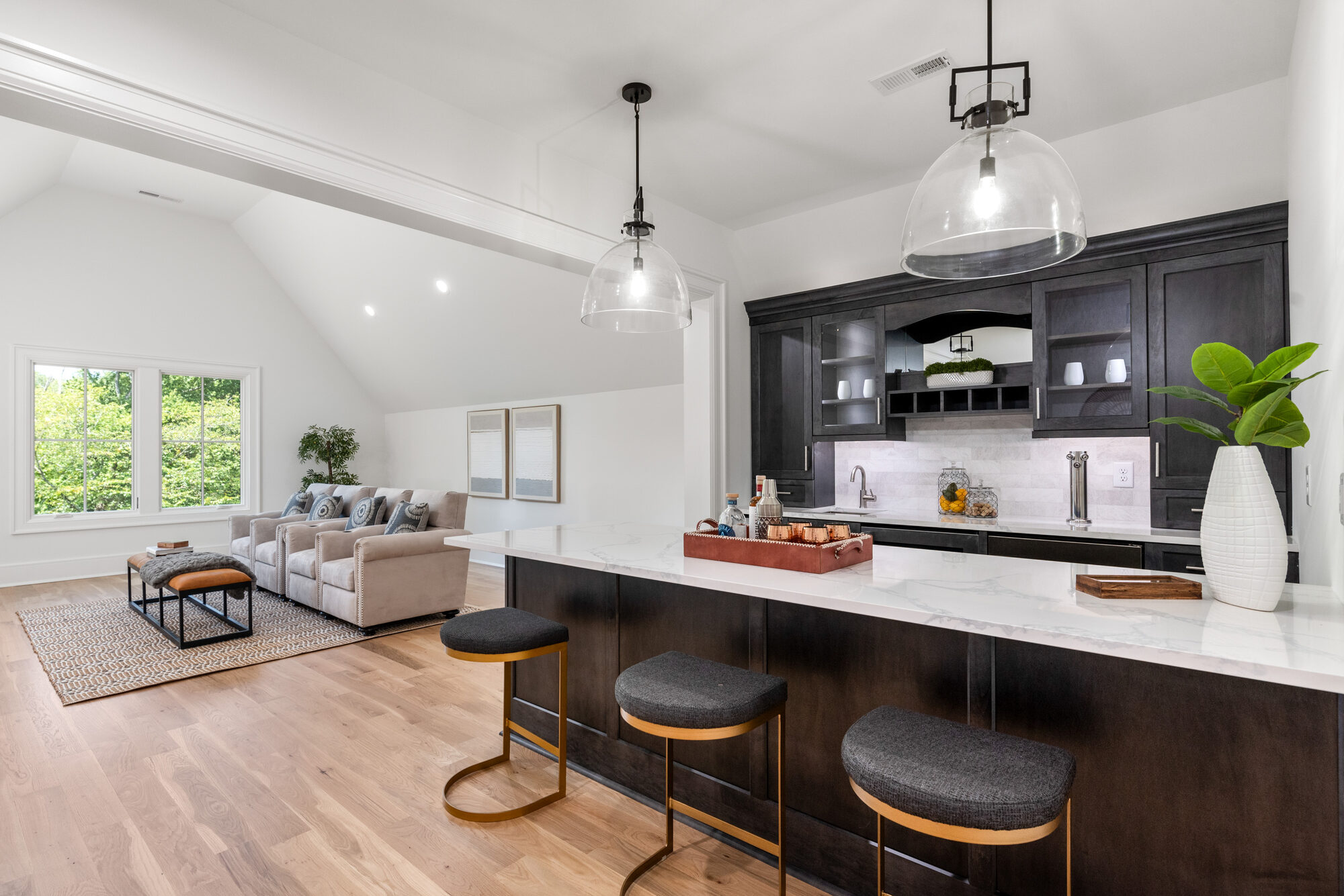 Walker upstairs entertainer's lounge with espresso wet bar, glass pendants, vaulted ceiling, and dedicated lounge seating — Stillman Properties Cotswold Charlotte NC