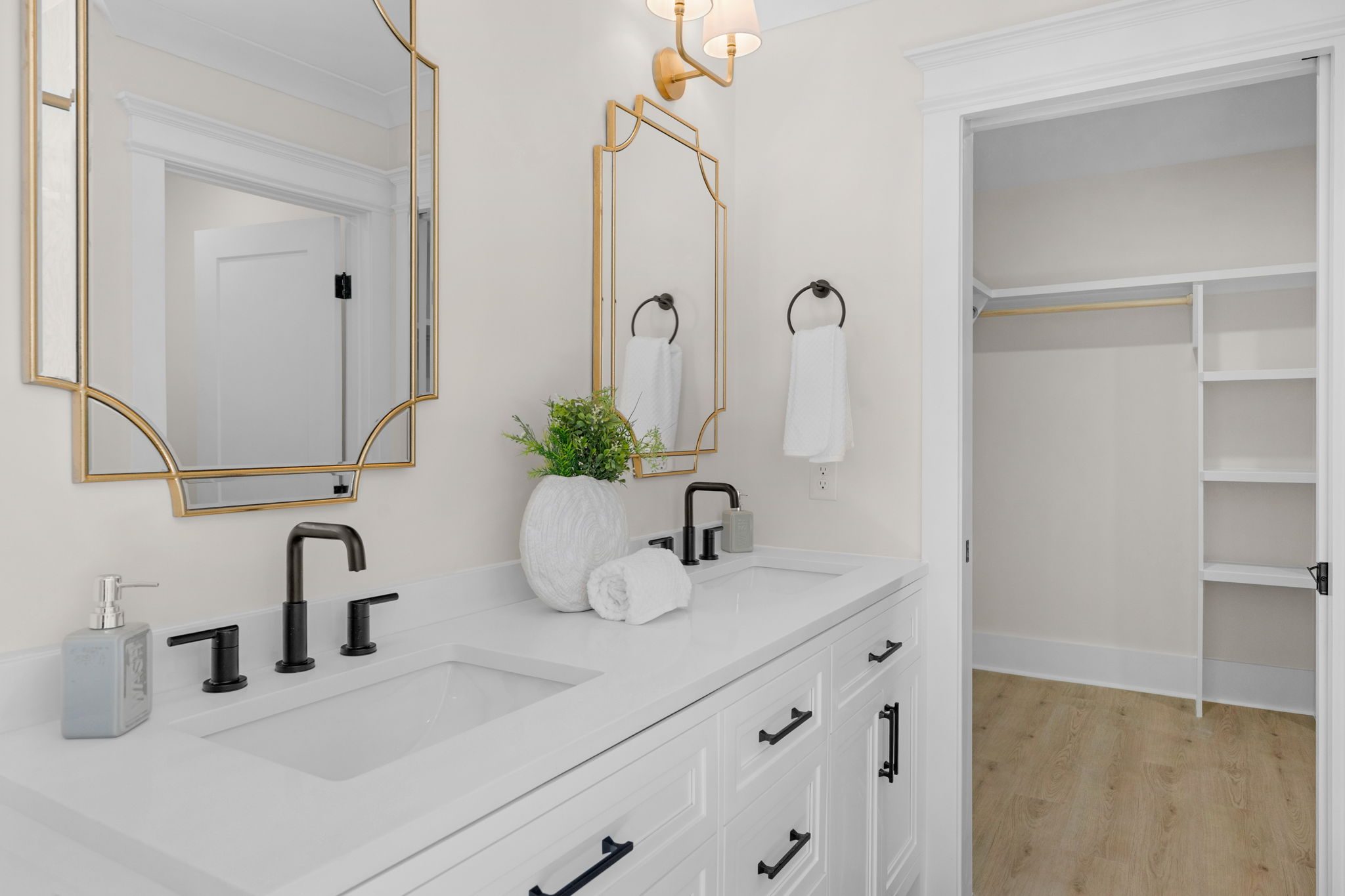 Primary bath with white vanity, gold fixtures, and framed mirror — Wyanoke by Stillman Properties Charlotte NC