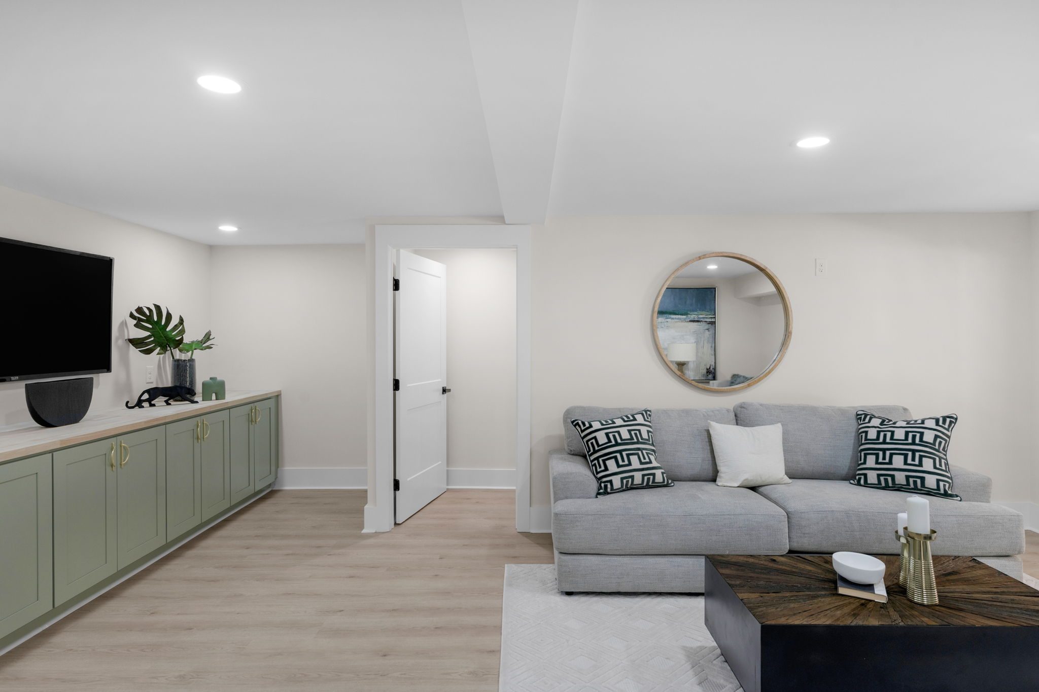 Lower-level living area with media wall and built-in cabinetry — Wyanoke by Stillman Properties Charlotte NC